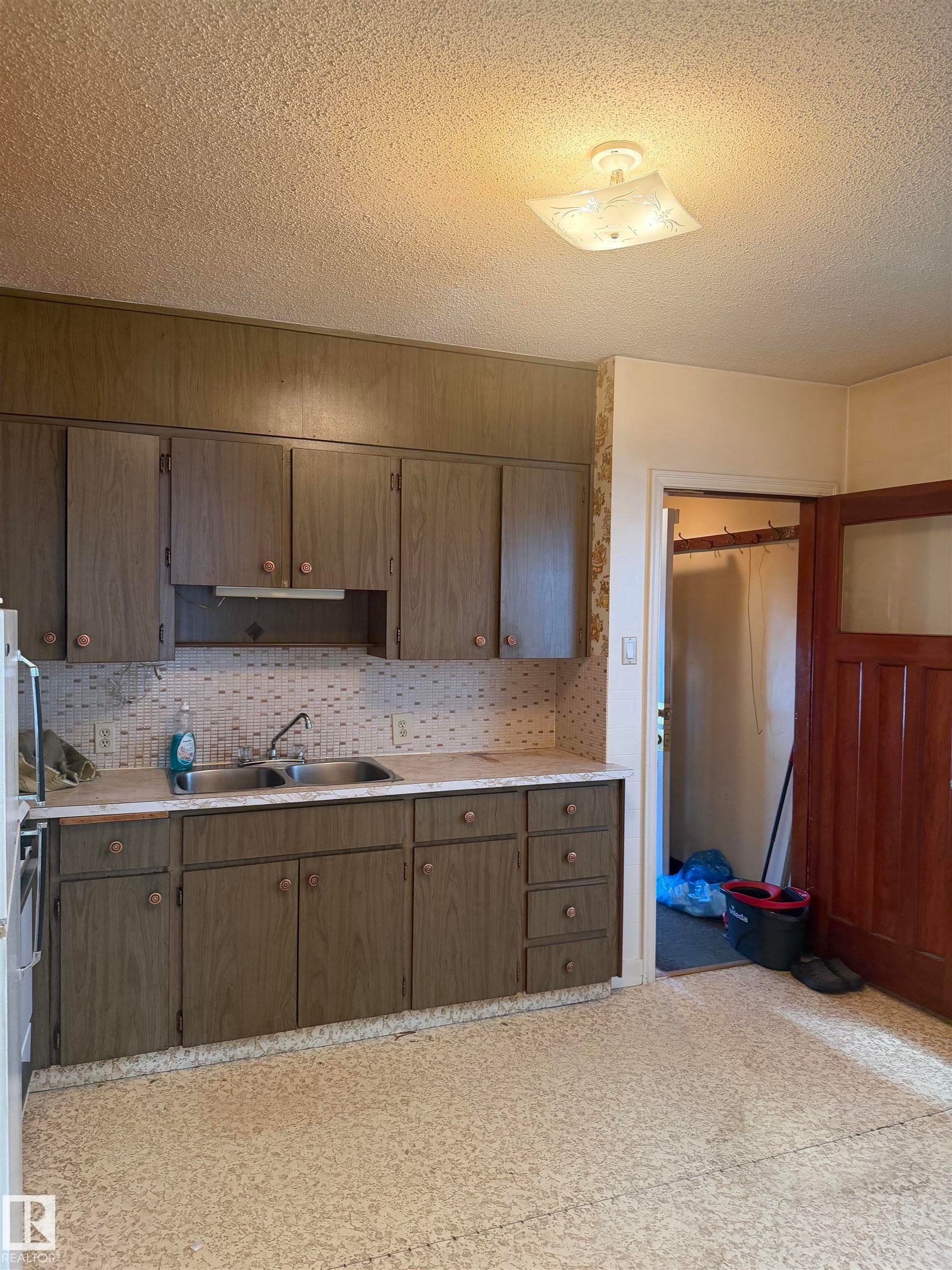 Kitchen area featuring extensive cabinetry and a double basin sink - 9630 106 Avenue, Edmonton, AB - Indoor Photo Showing Kitchen With Double Sink