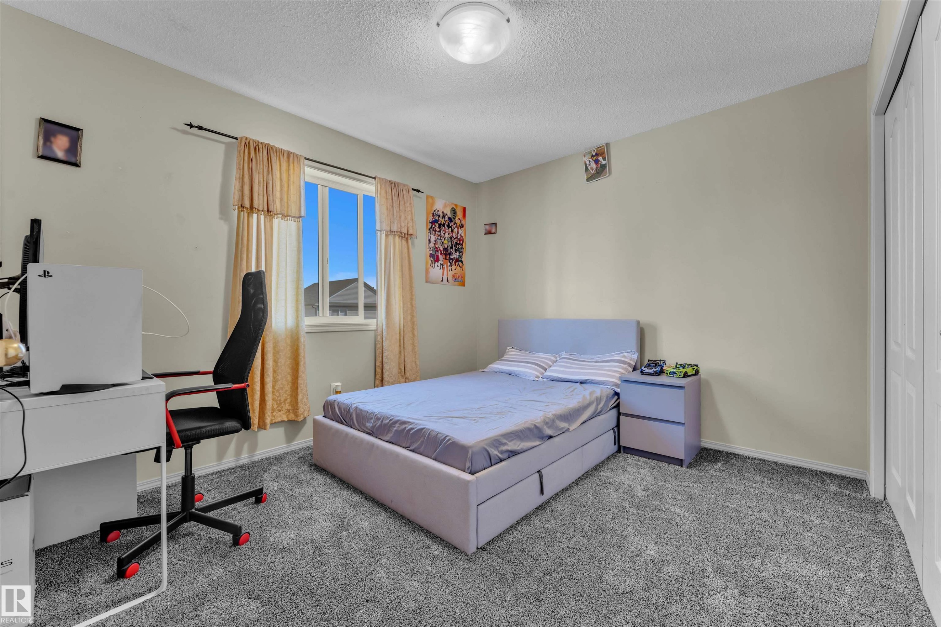 Bedroom with carpet flooring, a closet, a textured ceiling, and an office area - 6152 13 Avenue, Edmonton, AB - Indoor Photo Showing Bedroom