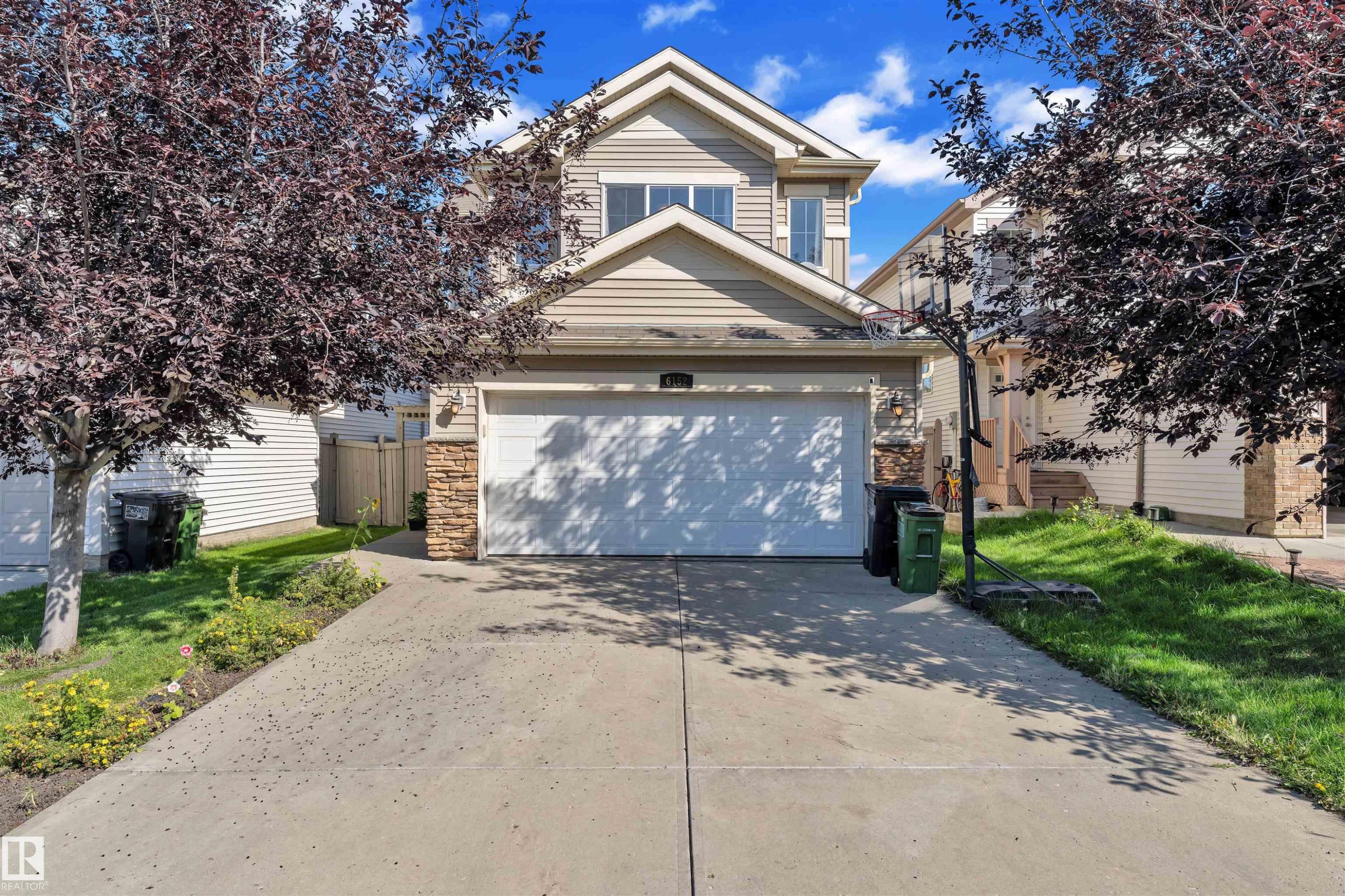 Traditional-style house with stone siding and concrete driveway - 6152 13 Avenue, Edmonton, AB - Outdoor
