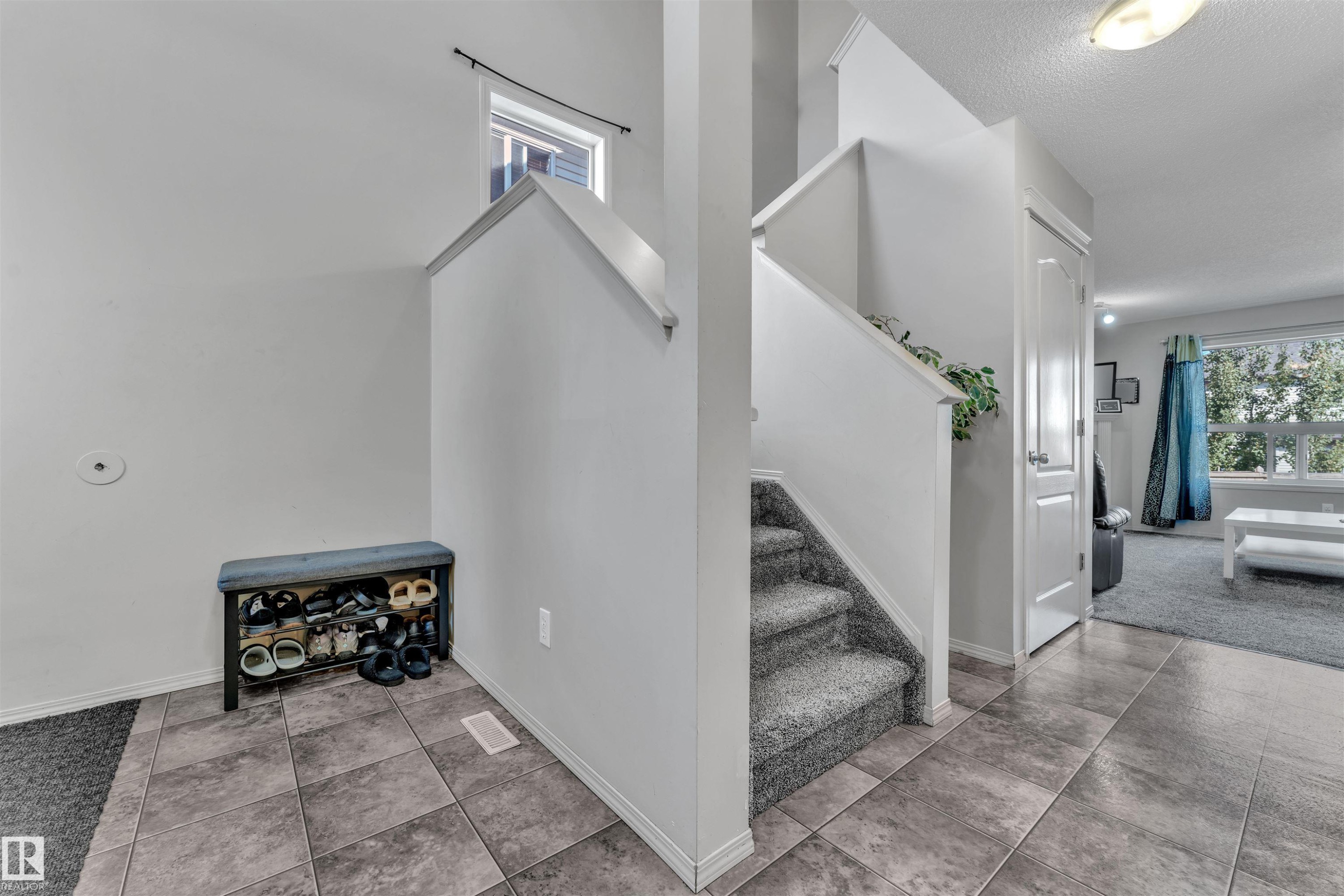 Stairs with tile patterned flooring and a textured ceiling - 6152 13 Avenue, Edmonton, AB - Indoor Photo Showing Other Room