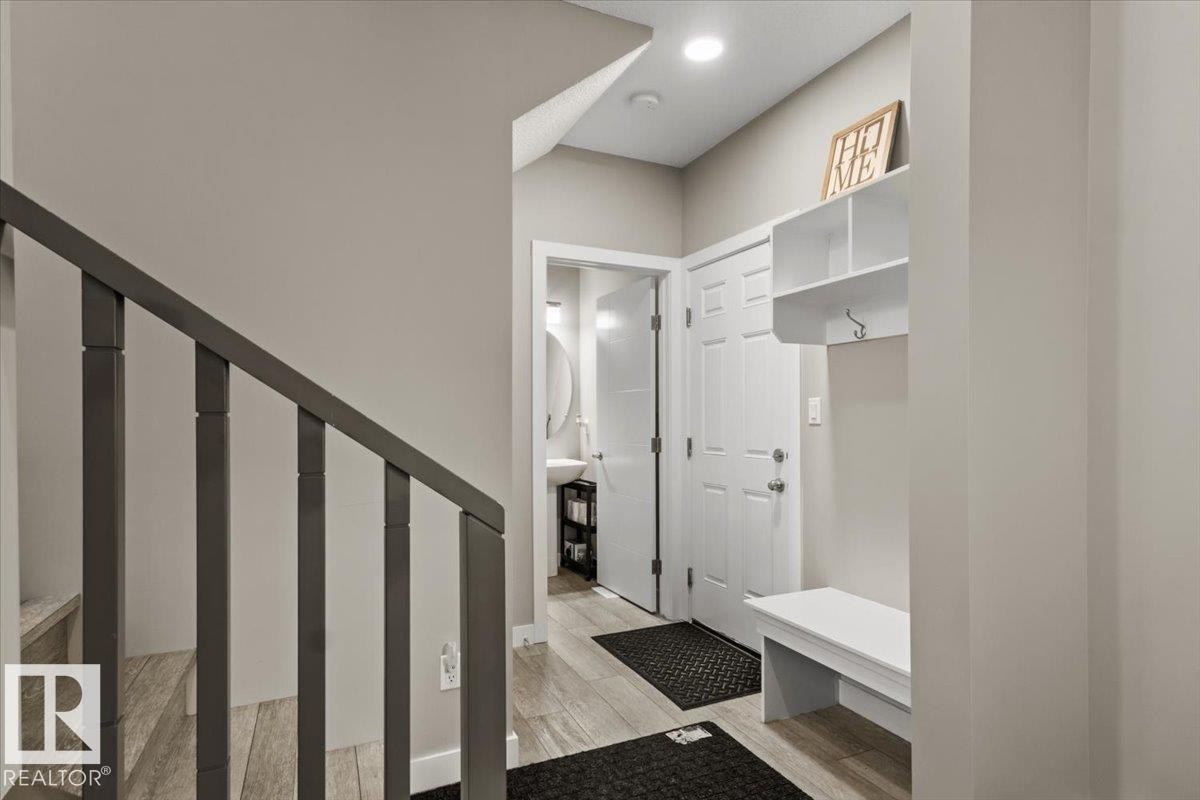 Entryway featuring wood-finish flooring, a white built-in storage bench, and an overhead storage shelf - 236 39 Avenue, Edmonton, AB - Indoor Photo Showing Other Room
