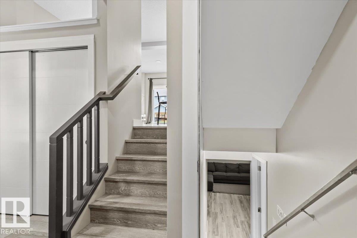 Interior staircase with wood-finish treads and a dark baluster railing - 236 39 Avenue, Edmonton, AB - Indoor Photo Showing Other Room