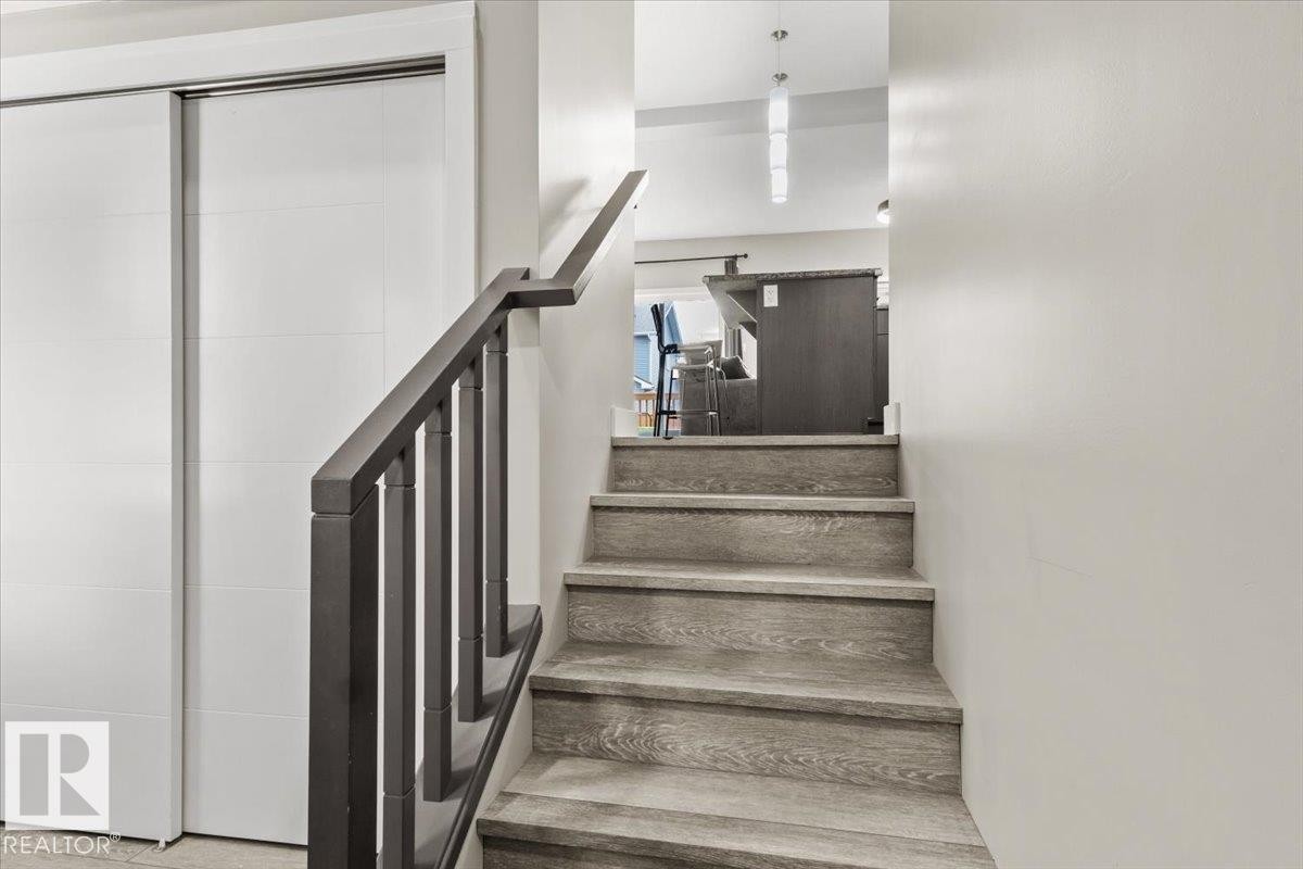 Staircase featuring wood-finish treads and risers, a dark wood newel post and balusters, and a matching handrail - 236 39 Avenue, Edmonton, AB - Indoor Photo Showing Other Room