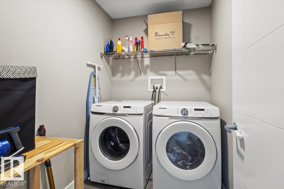 Dedicated laundry area featuring a front-loading washer and dryer, wall-mounted wire shelving, and neutral wall paint - 236 39 Avenue, Edmonton, AB - Indoor Photo Showing Laundry Room