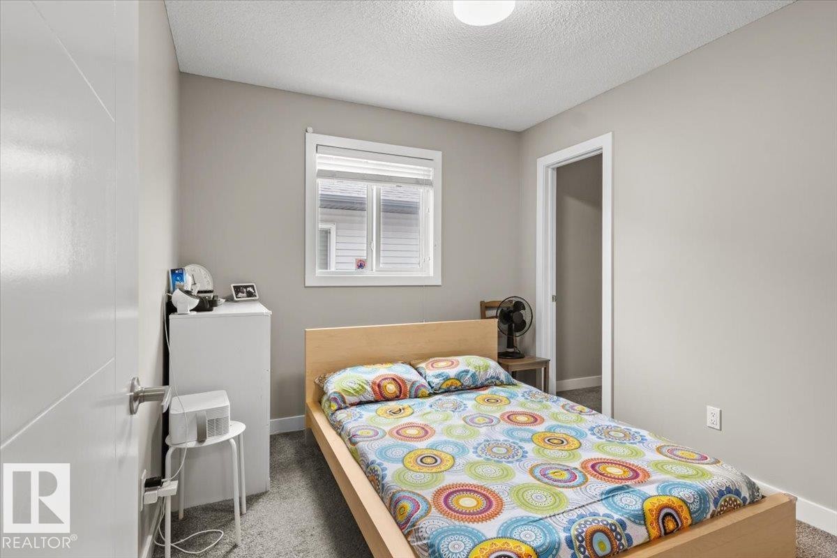 Carpeted room featuring a window with white blinds, a white flush-mount ceiling light, and a white interior door - 236 39 Avenue, Edmonton, AB - Indoor Photo Showing Bedroom