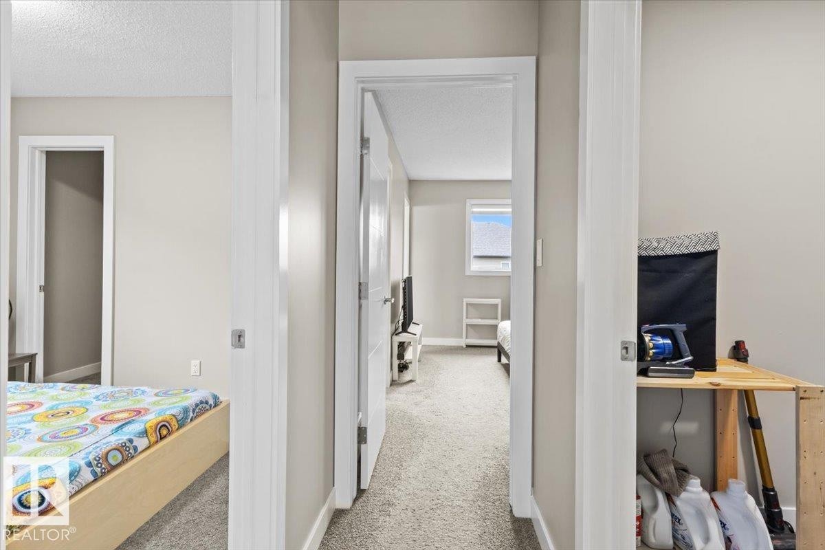 Interior hallway featuring neutral wall paint, white trim, white doors, and grey carpet flooring - 236 39 Avenue, Edmonton, AB - Indoor