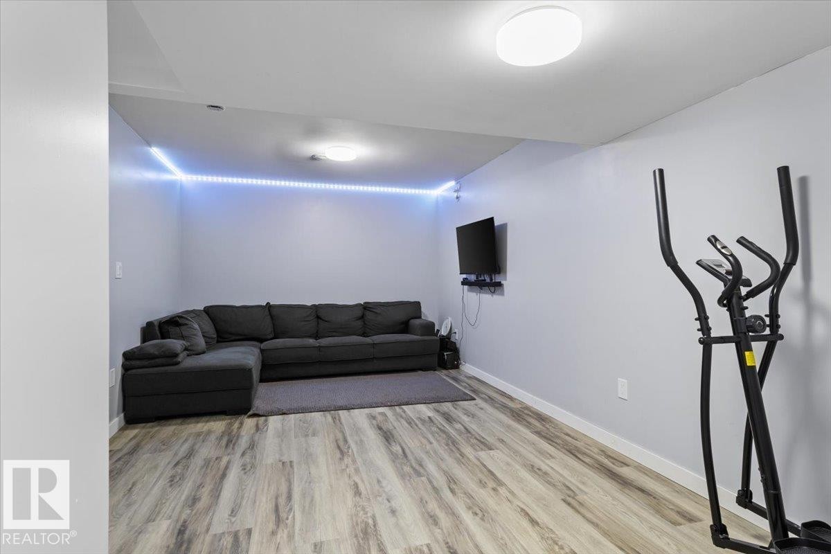 Spacious room featuring wood-finish flooring, light grey walls, and a recessed ceiling light - 236 39 Avenue, Edmonton, AB - Indoor