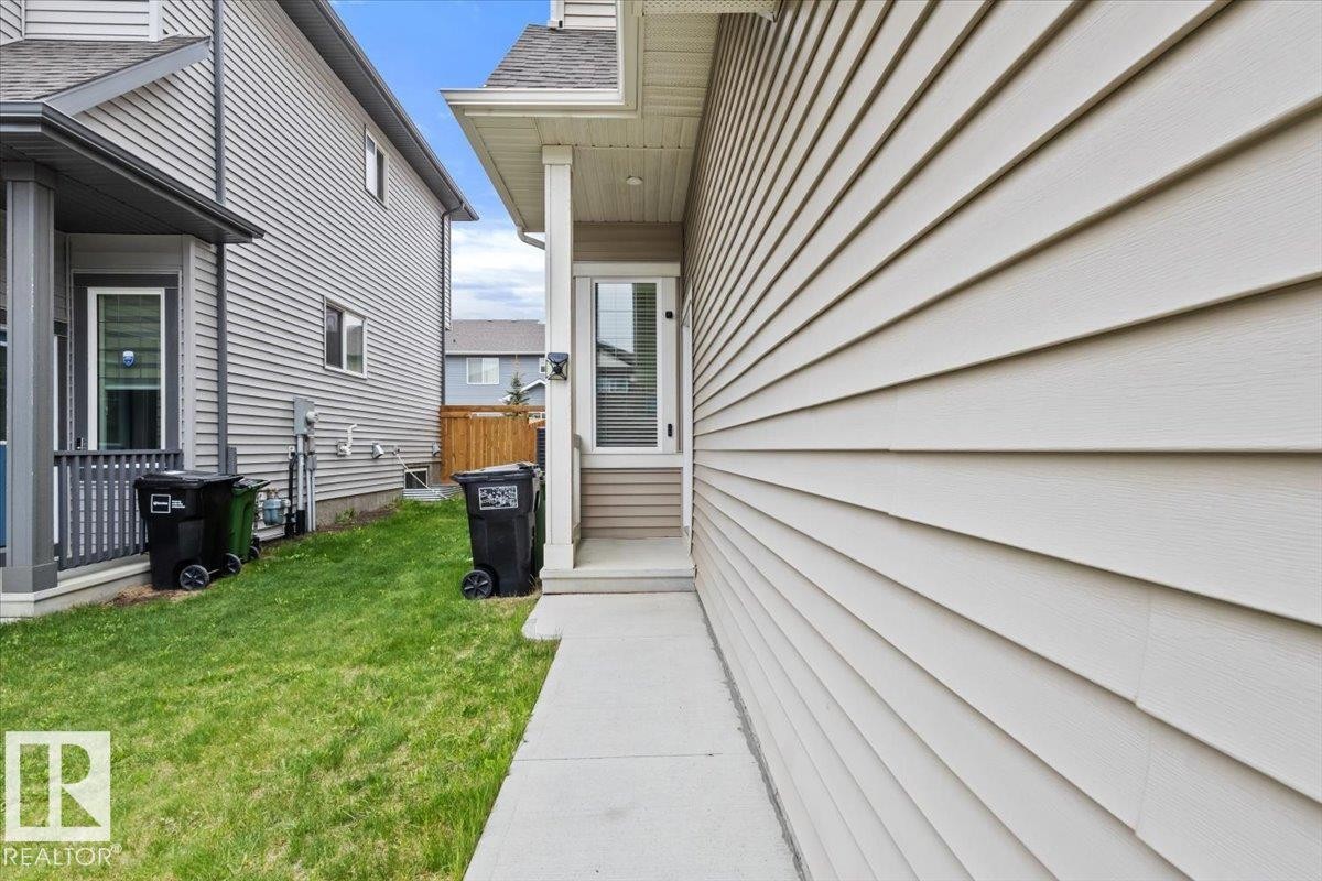 Property exterior featuring horizontal siding, a concrete pathway, and a side entrance with a transom window - 236 39 Avenue, Edmonton, AB - Outdoor