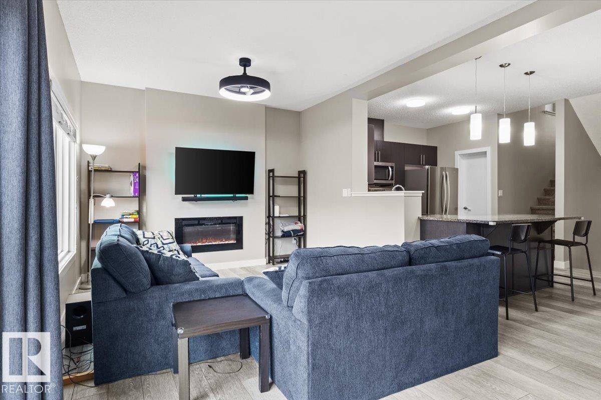 Open-concept living space featuring wood-finish flooring, an electric fireplace, and recessed lighting - 236 39 Avenue, Edmonton, AB - Indoor Photo Showing Living Room With Fireplace