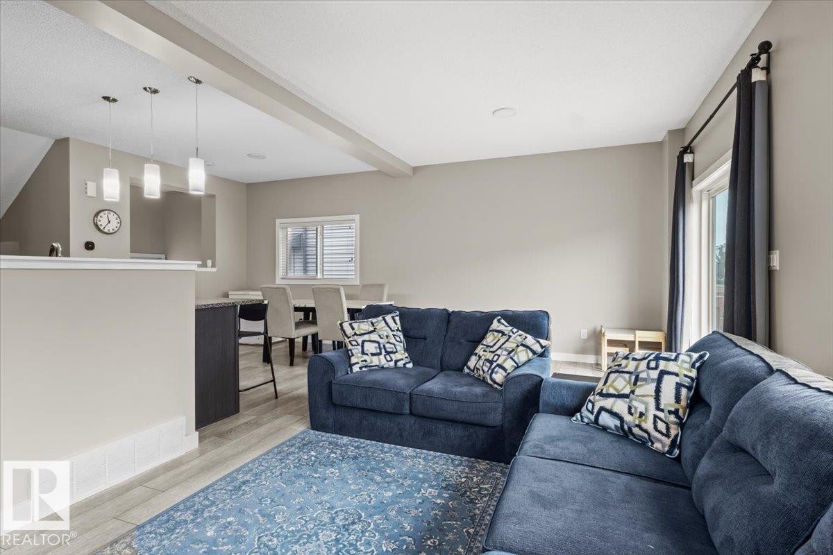 Open-concept living area featuring light-toned walls, wood-finish flooring, and recessed ceiling lights - 236 39 Avenue, Edmonton, AB - Indoor Photo Showing Living Room