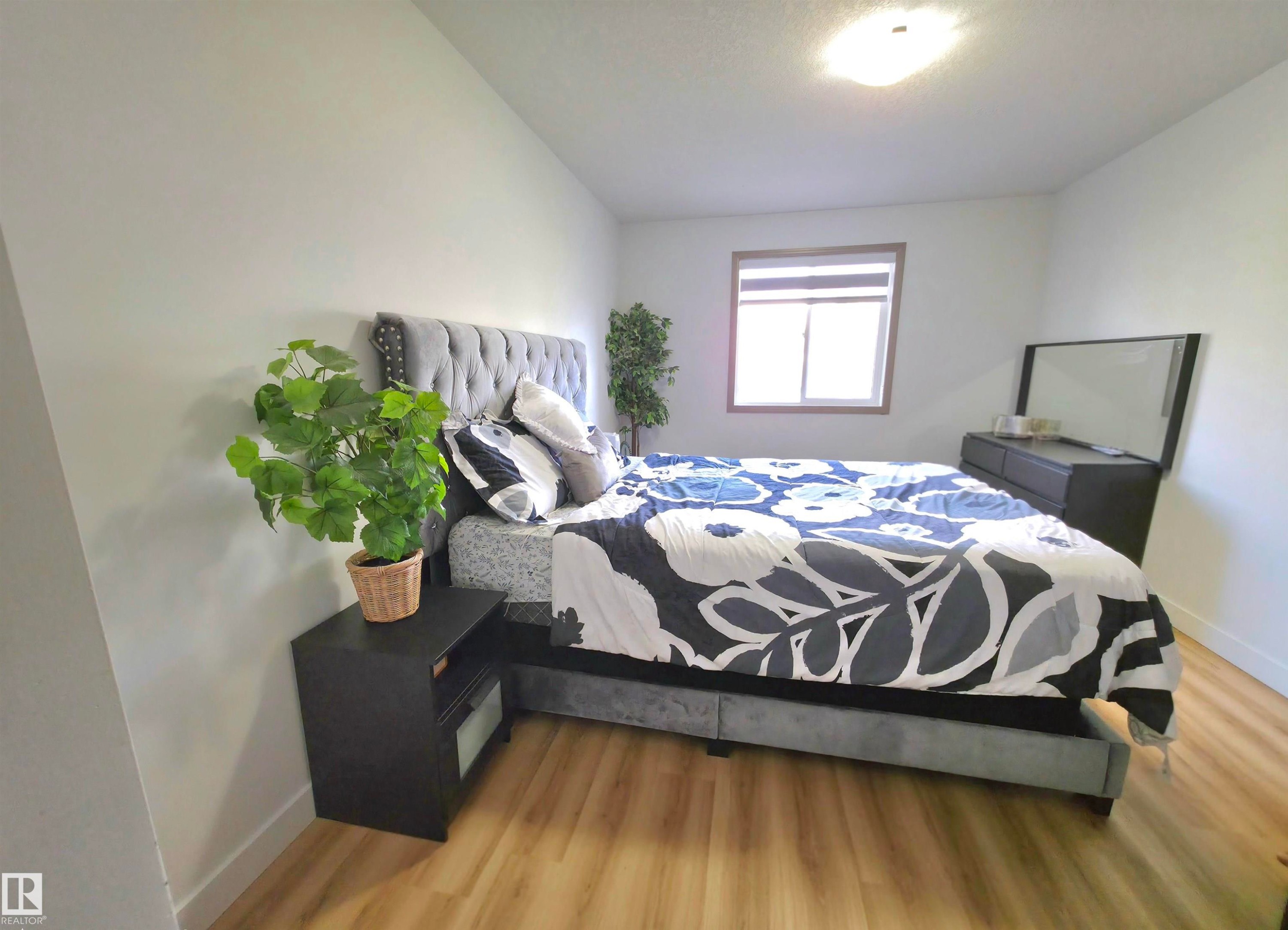 Light wood-finish flooring complements the neutral wall color - 210 5005 165 Avenue, Edmonton, AB - Indoor Photo Showing Bedroom