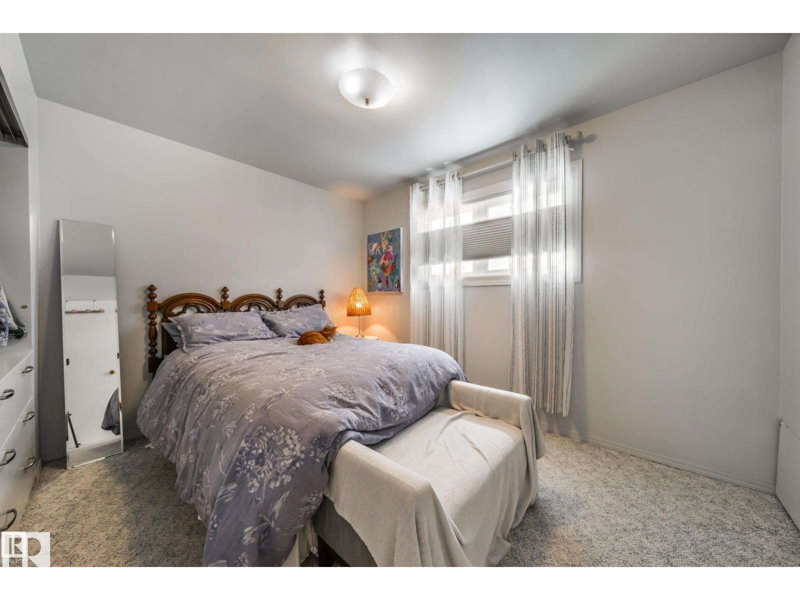Bedroom featuring a window with blinds and sheer curtains, overhead flush-mount lighting, and wall-to-wall carpeting - 10231 46 Street, Edmonton, AB