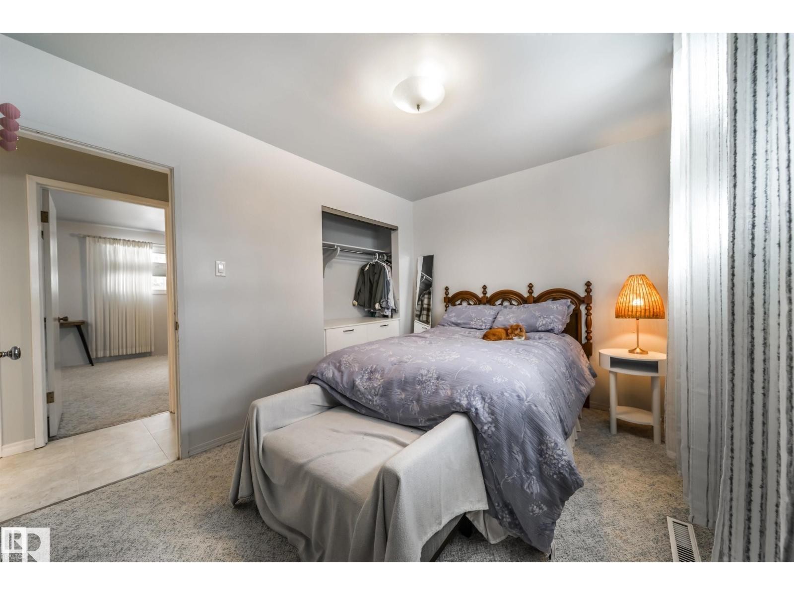 Carpeted bedroom with a built-in closet featuring shelving and hanging space - 10231 46 Street, Edmonton, AB