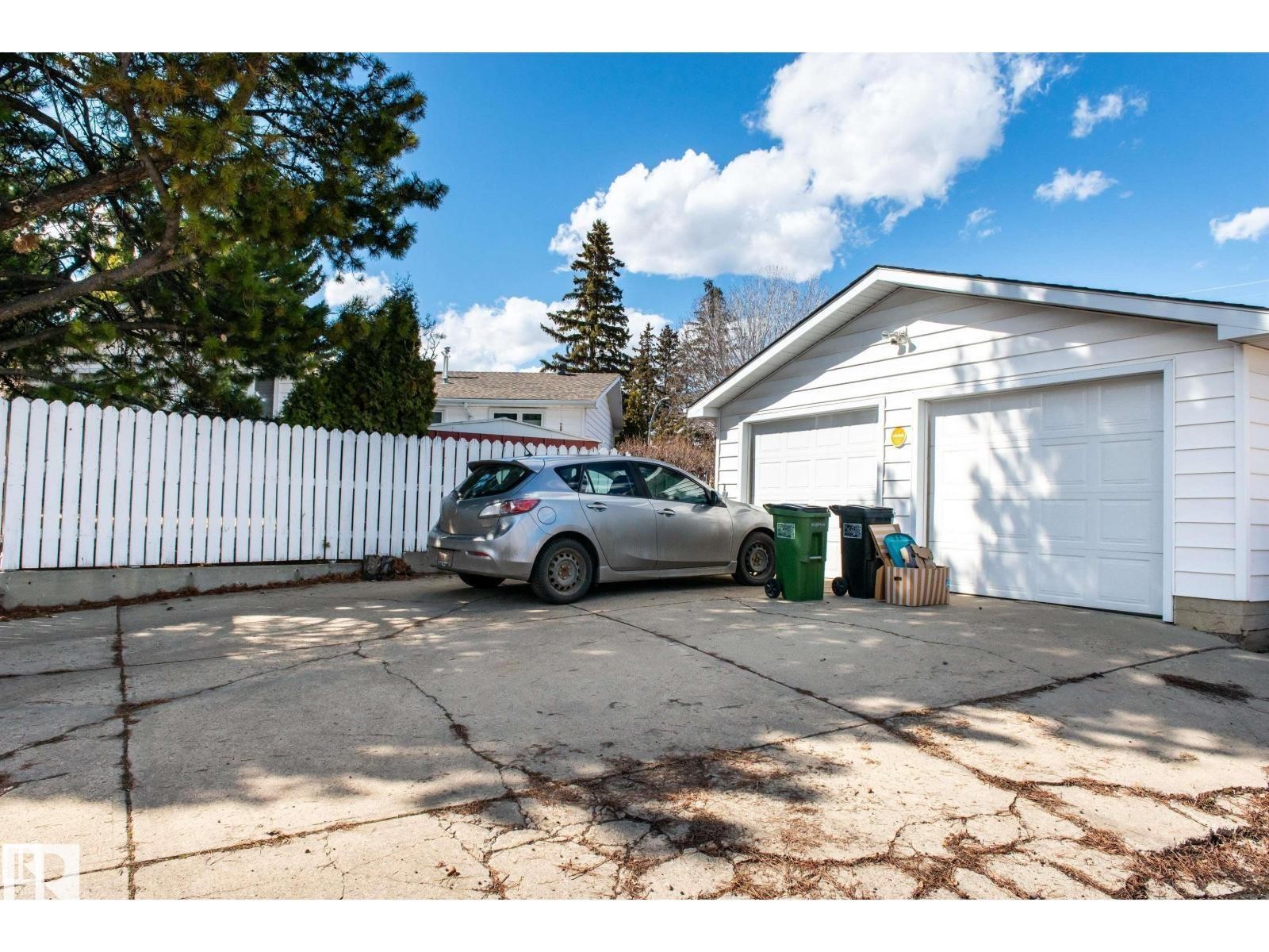 Detached two-car garage with white paneled garage doors and white siding - 10231 46 Street, Edmonton, AB