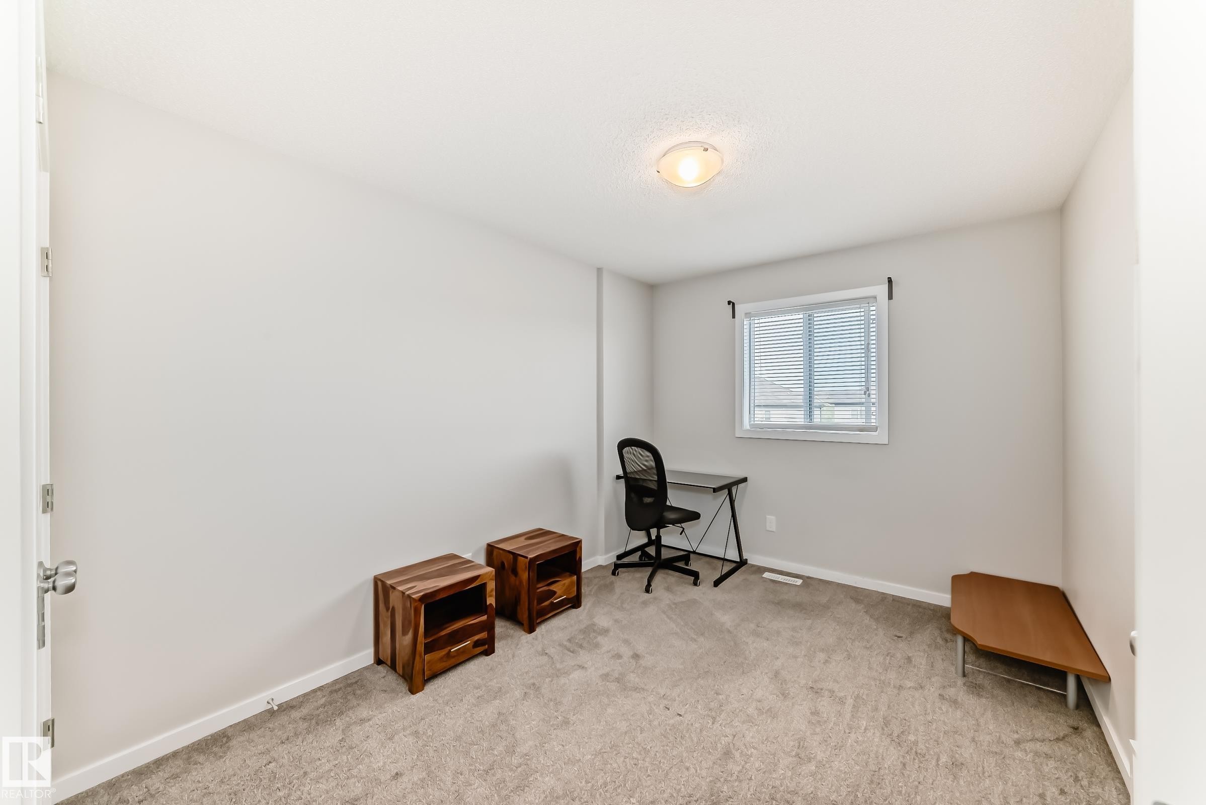 Spacious room featuring neutral carpeting, light-toned walls, and a single window with blinds - 328 Watt Boulevard, Edmonton, AB - Indoor