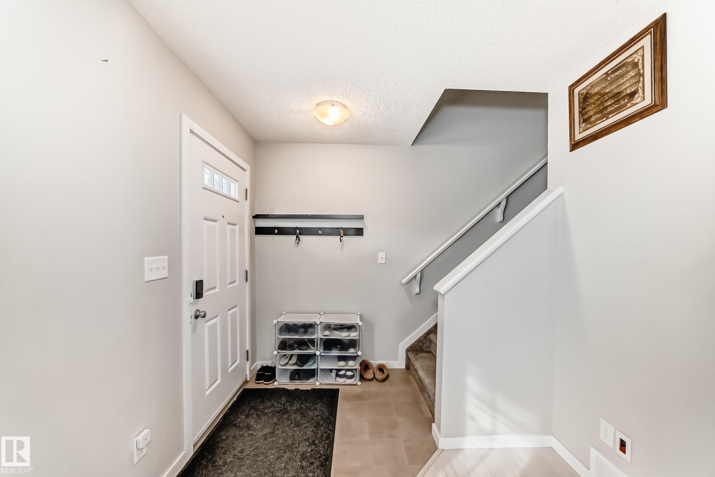 Entryway featuring a white paneled door with glass inserts, overhead flush-mount lighting, and a wall-mounted coat rack - 328 Watt Boulevard, Edmonton, AB - Indoor Photo Showing Other Room