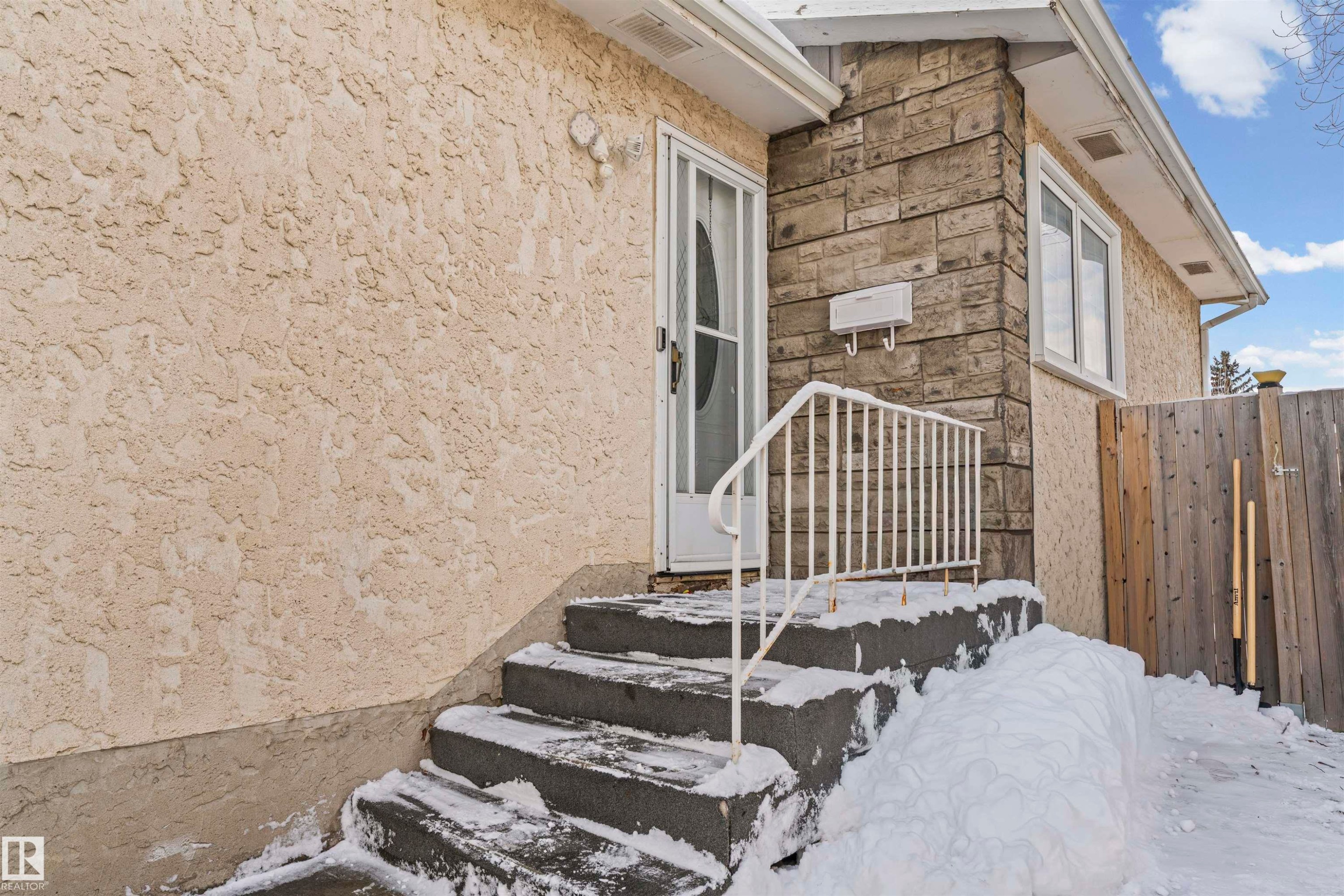 Exterior featuring textured stucco siding and a stone facade - 115 Warwick Road, Edmonton, AB - Outdoor