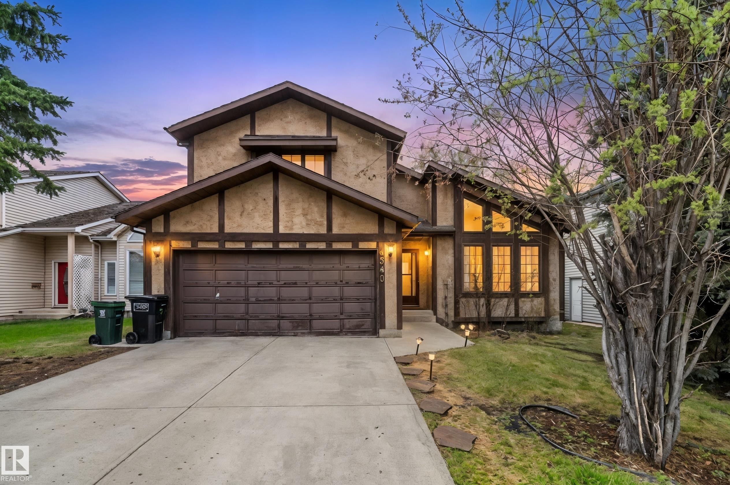 Two-story residence featuring stucco and dark trim accents, a two-car garage, and a concrete driveway - 4340 33 Street, Edmonton, AB - Outdoor