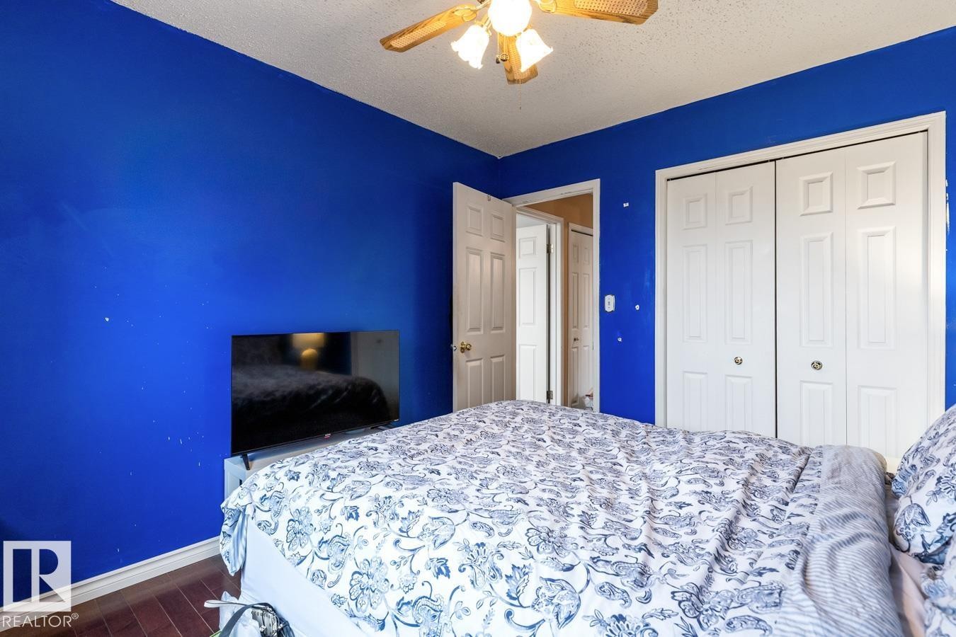 Bedroom featuring wood-finish flooring, a ceiling fan with light fixture, and white bi-fold closet doors - 4340 33 Street, Edmonton, AB - Indoor Photo Showing Bedroom