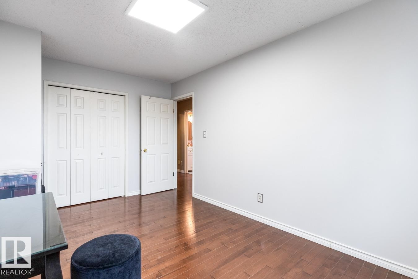 Room featuring wood-finish flooring, white baseboards, and light gray walls - 4340 33 Street, Edmonton, AB - Indoor