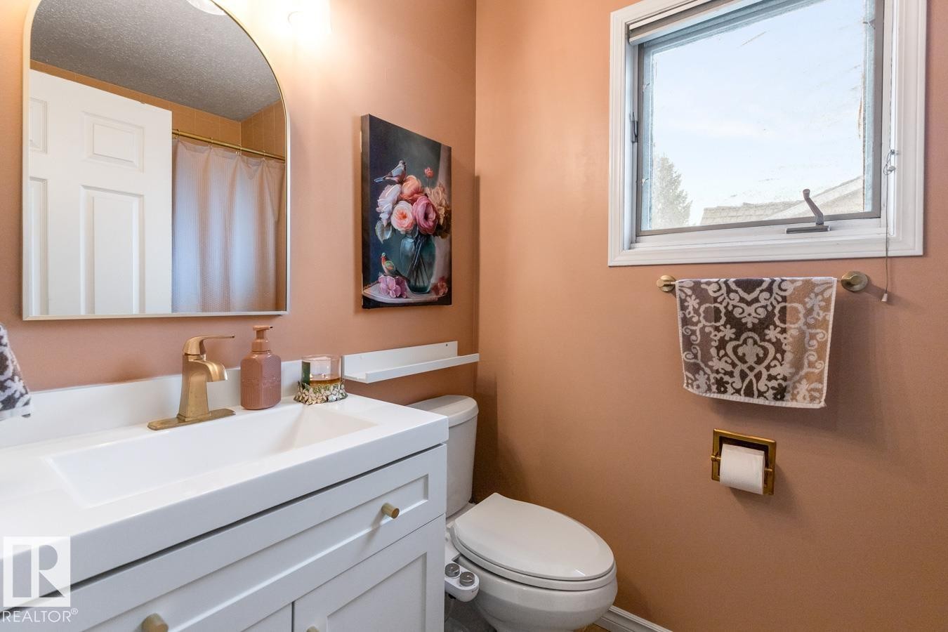 Bathroom featuring a white vanity with integrated sink, brass-finish faucet, and coordinating hardware - 4340 33 Street, Edmonton, AB - Indoor Photo Showing Bathroom