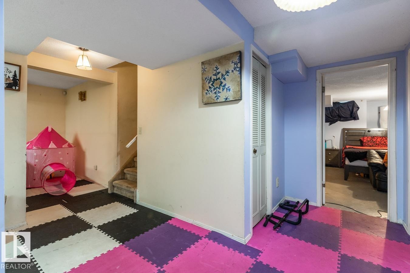 Multipurpose lower level area featuring checkerboard foam flooring and a carpeted staircase - 4340 33 Street, Edmonton, AB - Indoor