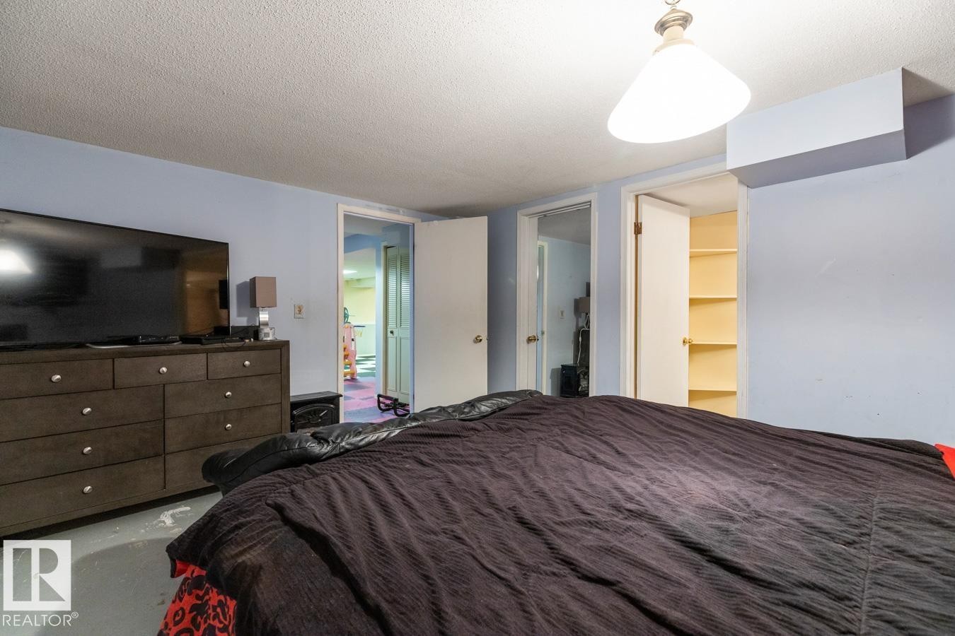 Interior room featuring light blue walls, a white ceiling, and a ceiling-mounted light fixture - 4340 33 Street, Edmonton, AB - Indoor Photo Showing Bedroom