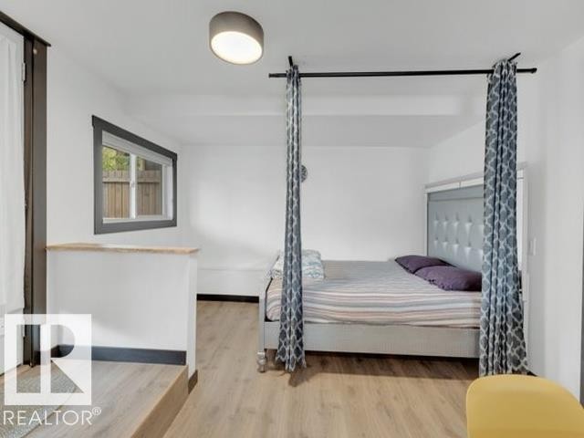 Bright interior space featuring wood-finish flooring, white walls, and a contemporary flush-mount ceiling light - 3602 50Th Ave, Sylvan Lake, AB - Indoor Photo Showing Bedroom