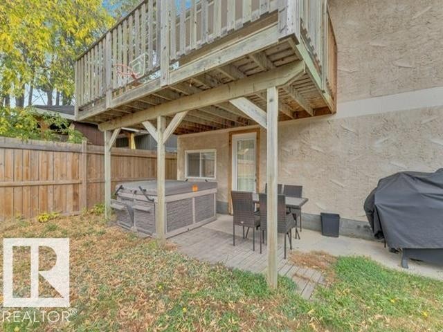 Spacious outdoor area with a ground-level deck, a built-in spa, and a private wooden fence - 3602 50Th Ave, Sylvan Lake, AB - Outdoor