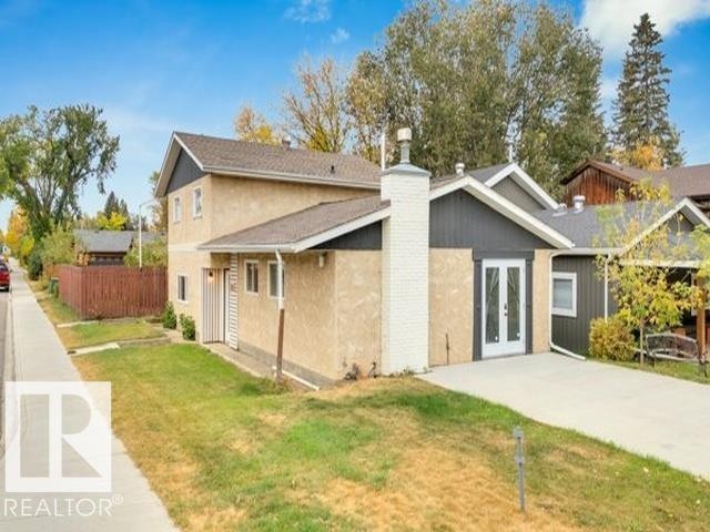 Multi-level property featuring stucco siding, a white brick chimney, and dark gray gables - 3602 50Th Ave, Sylvan Lake, AB - Outdoor