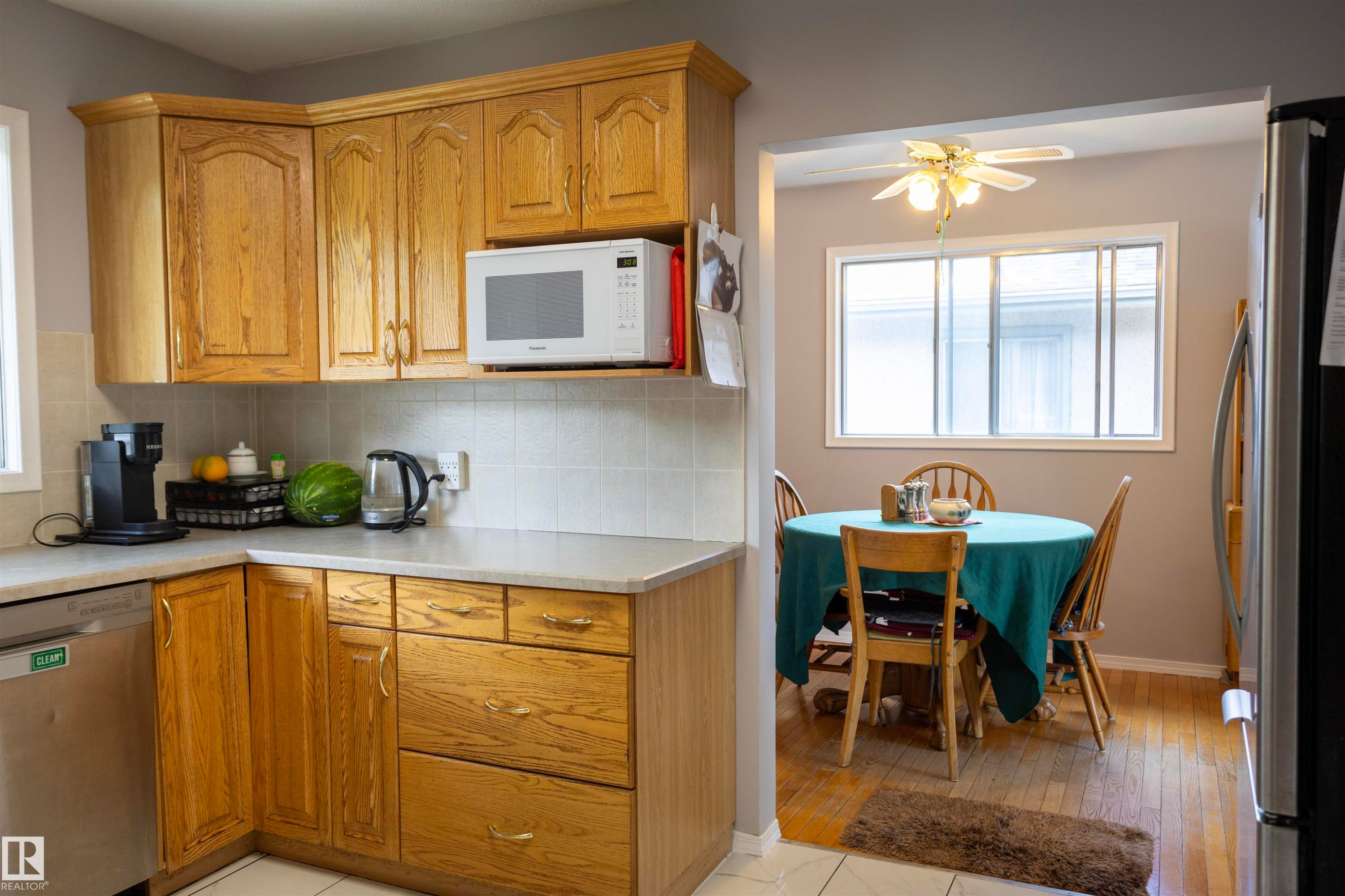 Kitchen featuring wood cabinetry, white tiled backsplash, and light-toned countertops - 10428 68 Avenue, Edmonton, AB - Indoor Photo Showing Other Room