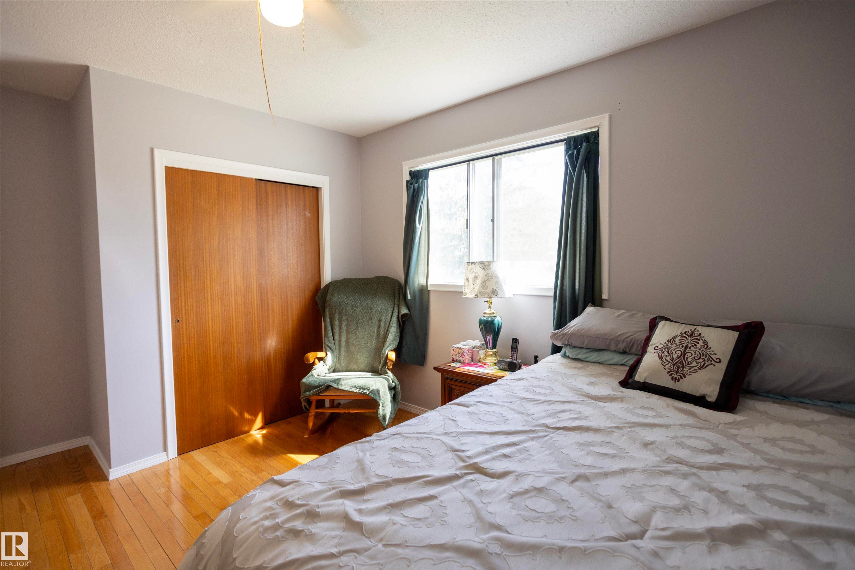 Wood-finish flooring with light gray walls - 10428 68 Avenue, Edmonton, AB - Indoor Photo Showing Bedroom