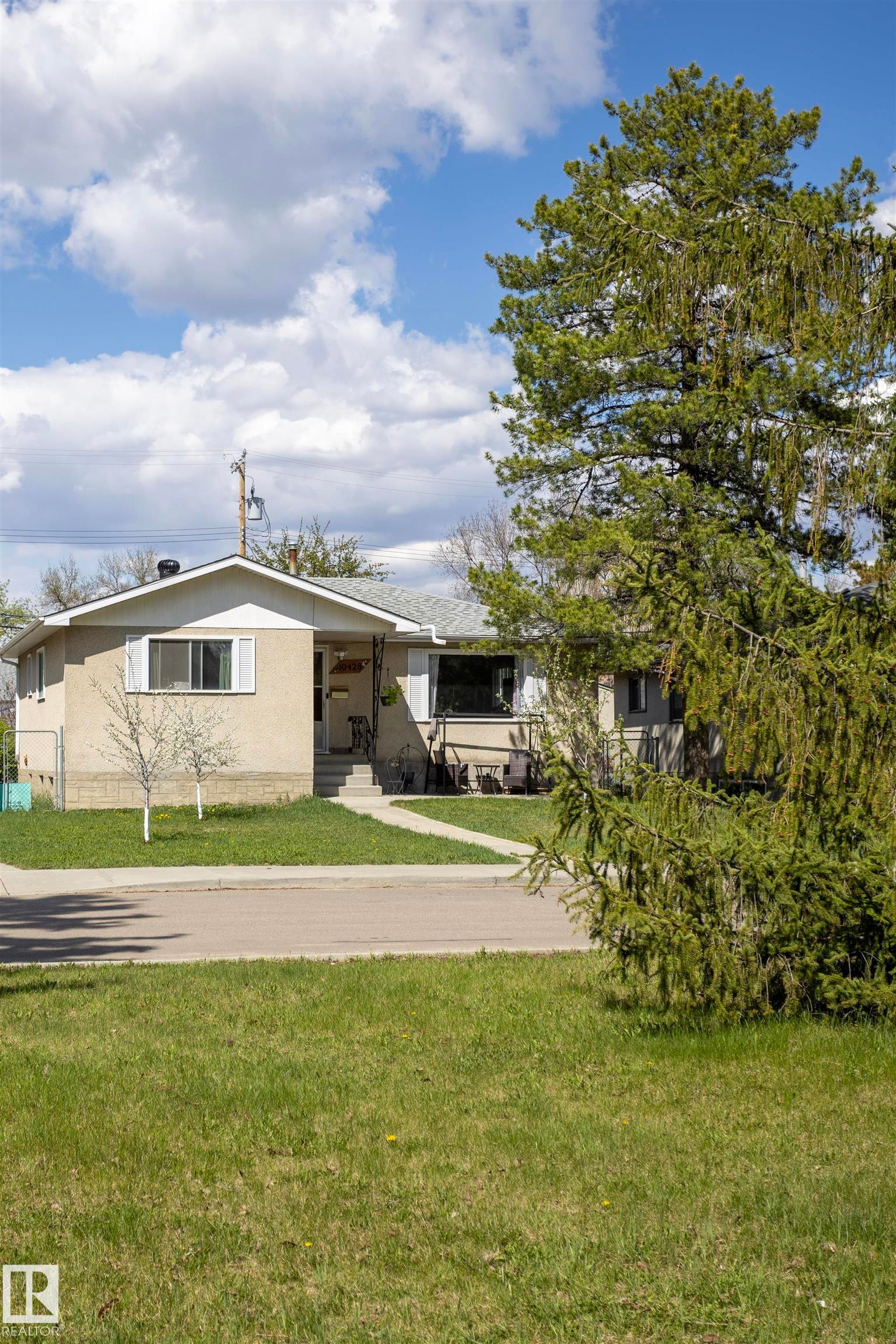 Single-story residence featuring light-colored stucco siding, a gray shingle roof, and white trim - 10428 68 Avenue, Edmonton, AB - Outdoor