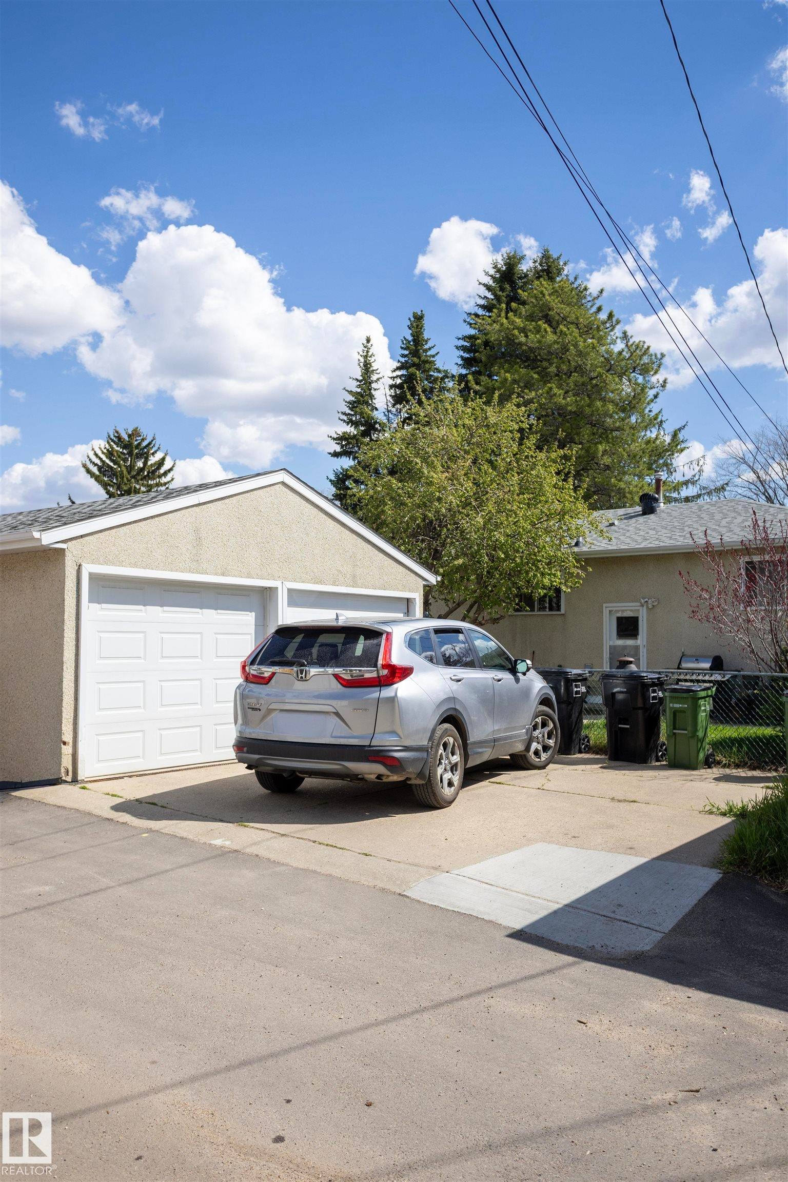 Detached two-car garage with white panel doors and a concrete driveway - 10428 68 Avenue, Edmonton, AB - Outdoor