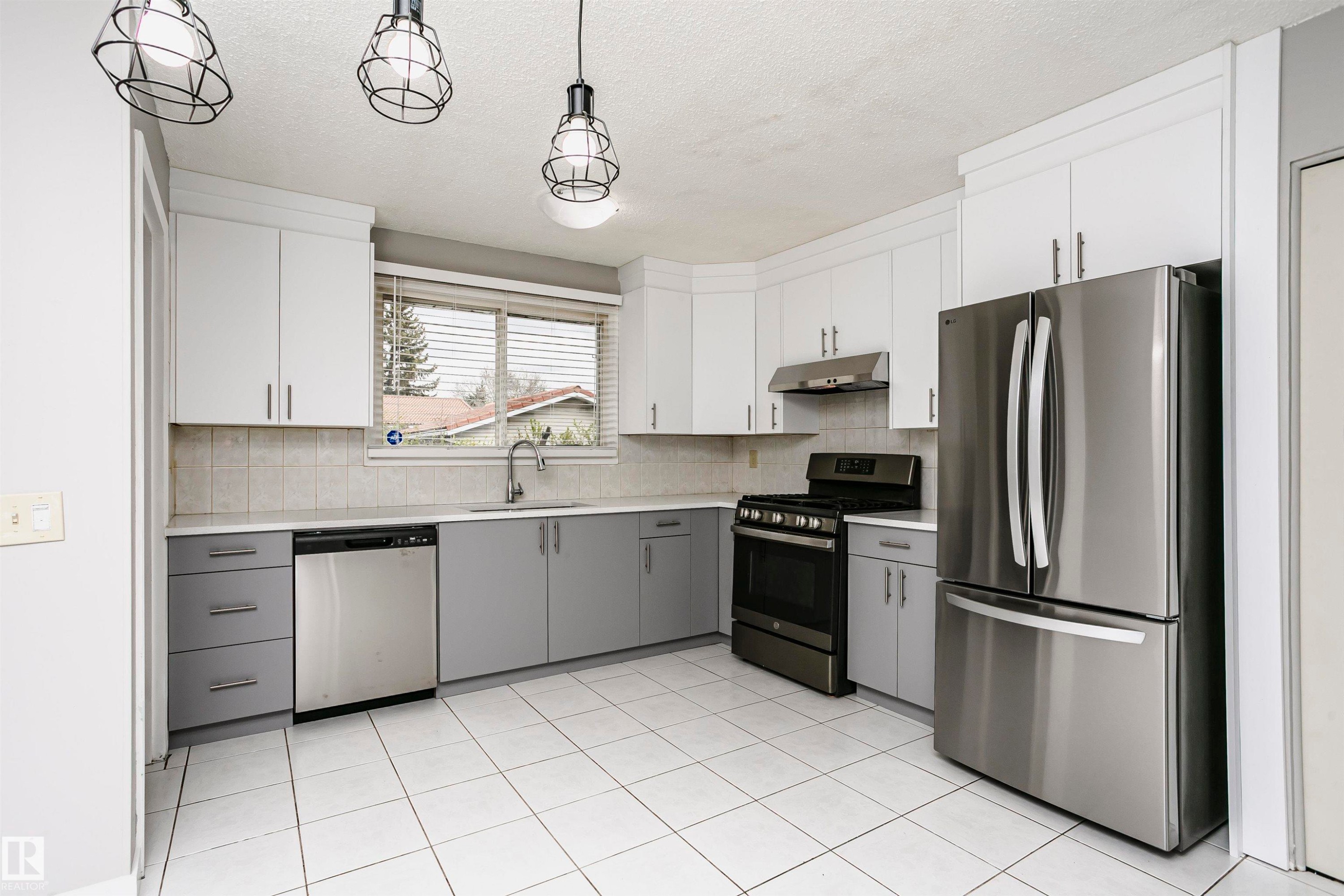 Spacious country kitchen with large dinette area & st/steel appliances. Beautiful new custom cabinetry and quartz countertops. Undermount st/st farmhouse sink & new faucet. Tile backsplash. New st/st fridge and dishwasher. Gas stove and hood fan. - 11436 161 Avenue, Edmonton, AB - Indoor Photo Showing Kitchen