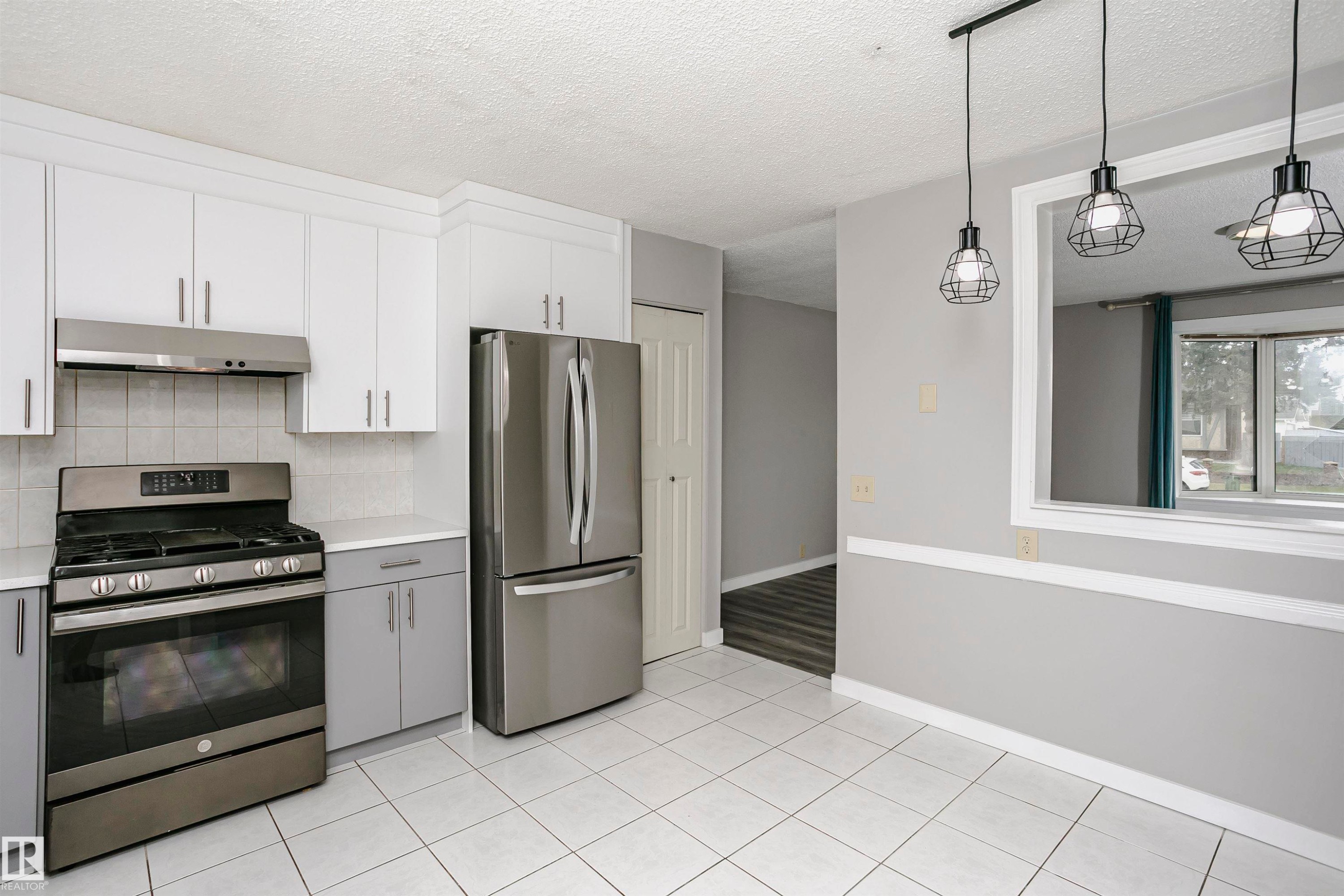 Enjoy added natural light from cut through to living room into kitchen and dinette area. Attractive lighting has been upgraded. - 11436 161 Avenue, Edmonton, AB - Indoor Photo Showing Kitchen