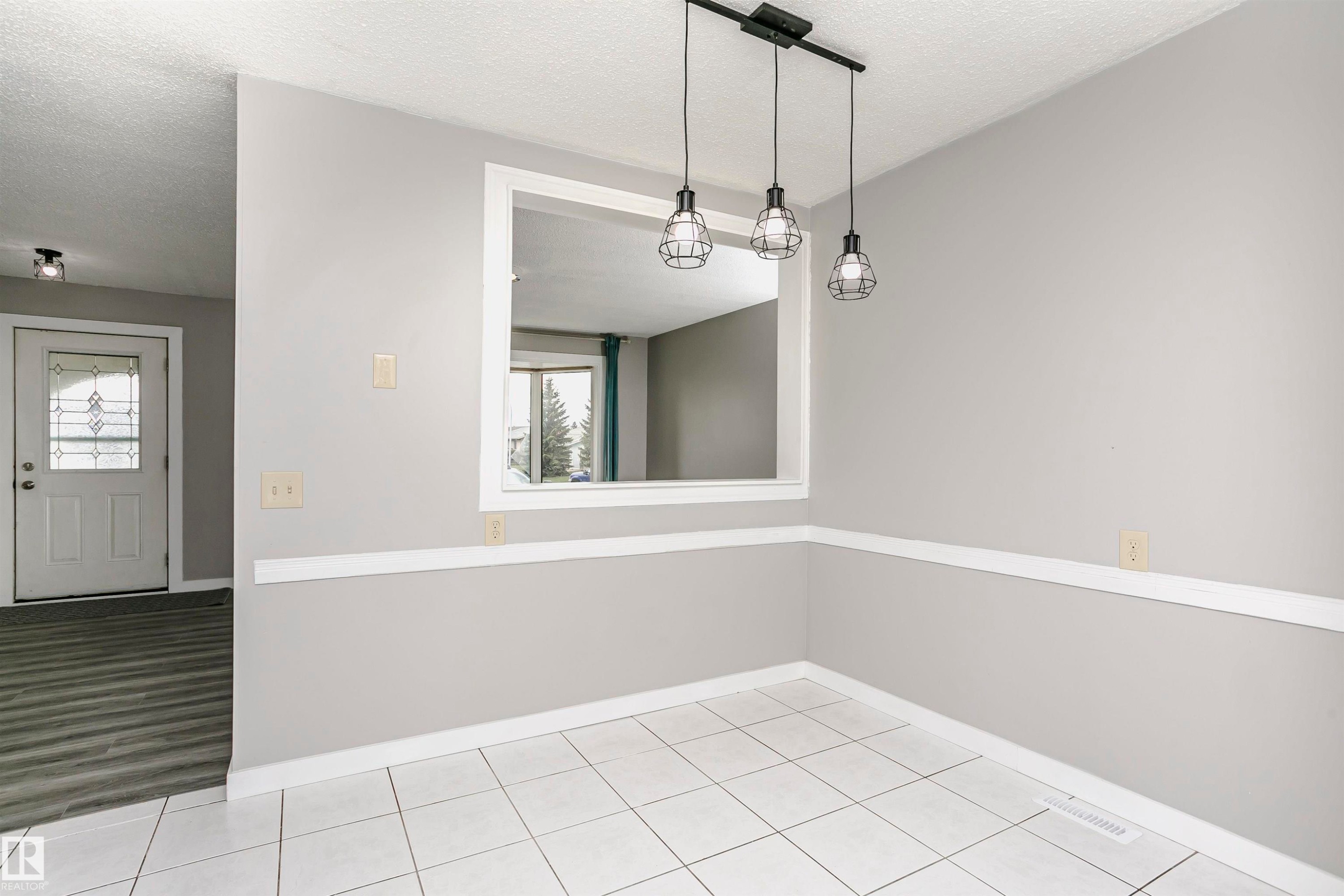Spacious eat in dinette area with attractive lighting in kitchen. Tile flooring and convenient cut through to living room adds natural light. - 11436 161 Avenue, Edmonton, AB - Indoor Photo Showing Other Room