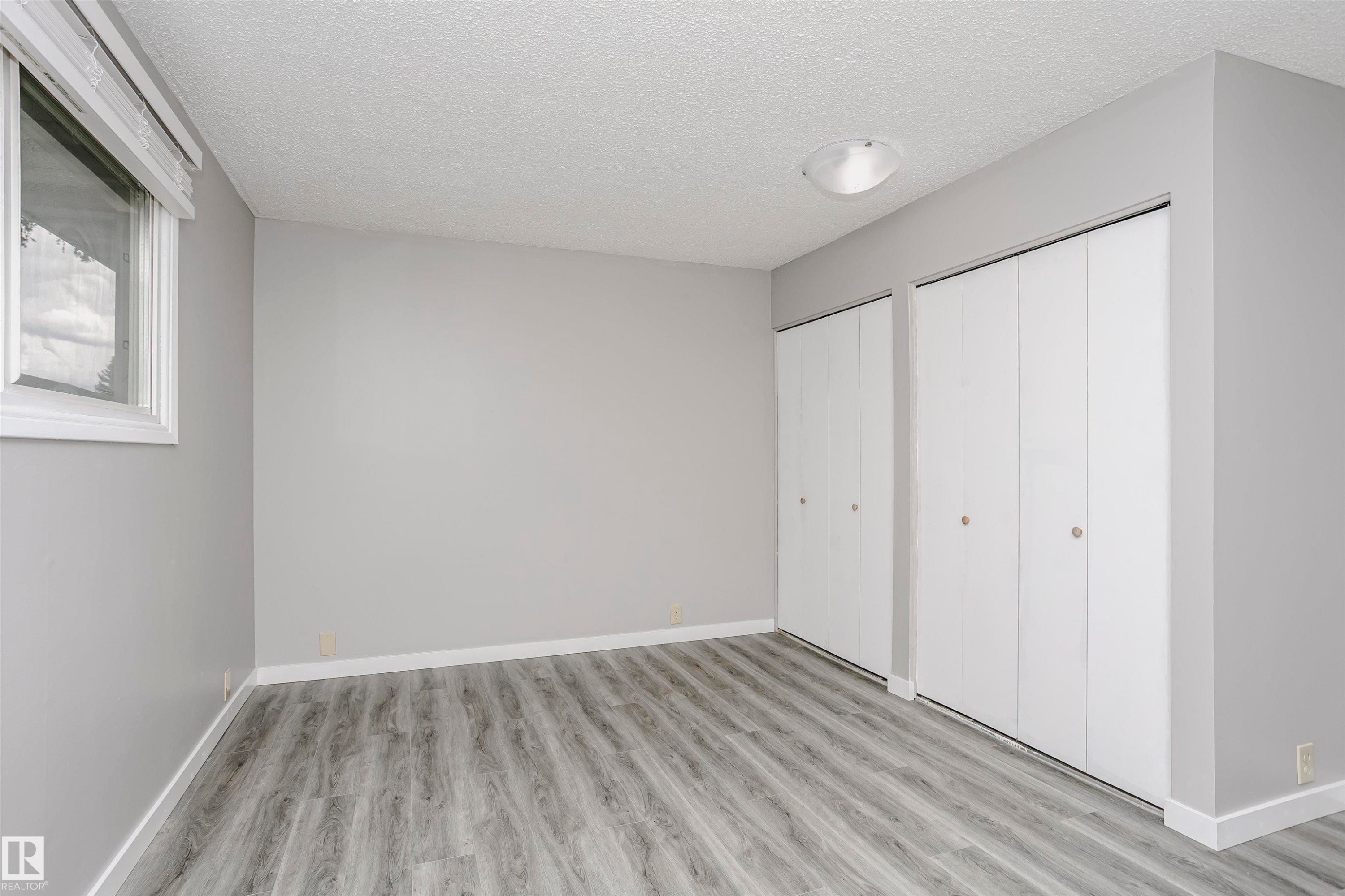 Spacious primary bedroom with double closet and new vinyl plank flooring. All 3 bedrooms have new vinyl plank. - 11436 161 Avenue, Edmonton, AB - Indoor Photo Showing Other Room