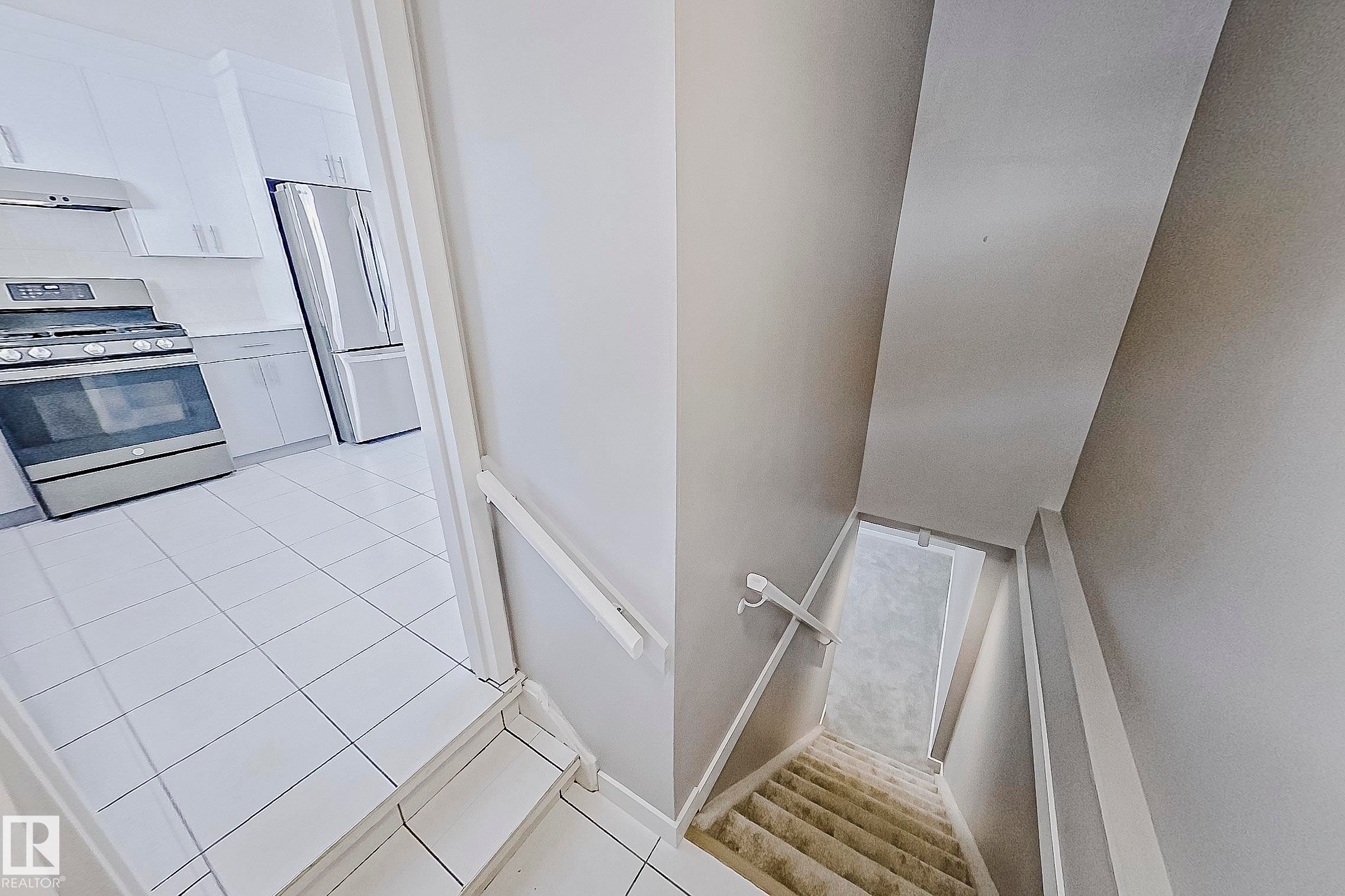 Staircase to basement with new plush carpet. This rear entry would be ideal for a future suite. - 11436 161 Avenue, Edmonton, AB - Indoor Photo Showing Other Room
