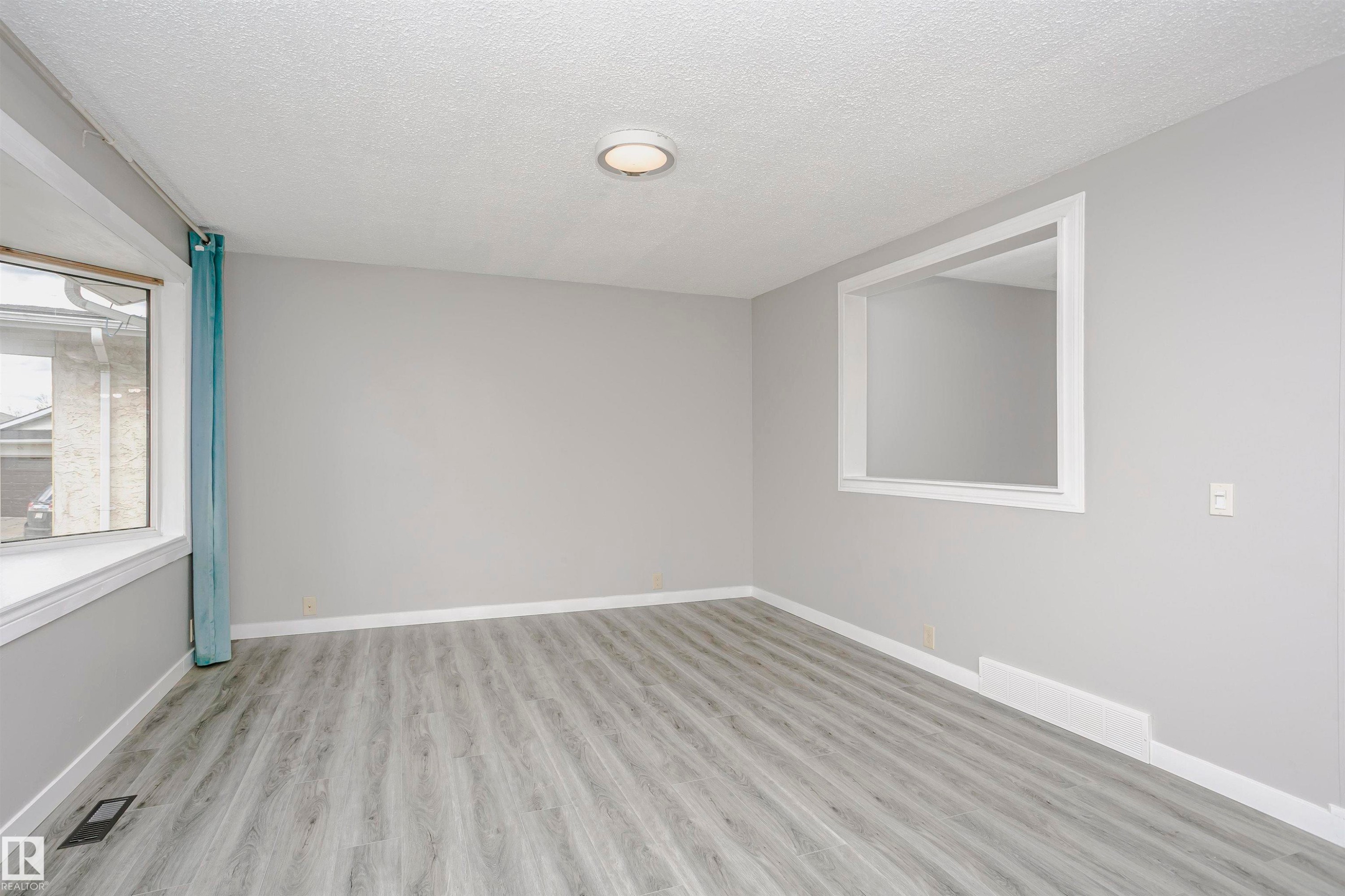 Bay window in living room. Beautiful new vinyl plank flooring. Convenient cut through in wall to kitchen and dinette area for added natural light. Freshly painted throughout and new lighting. - 11436 161 Avenue, Edmonton, AB - Indoor Photo Showing Other Room