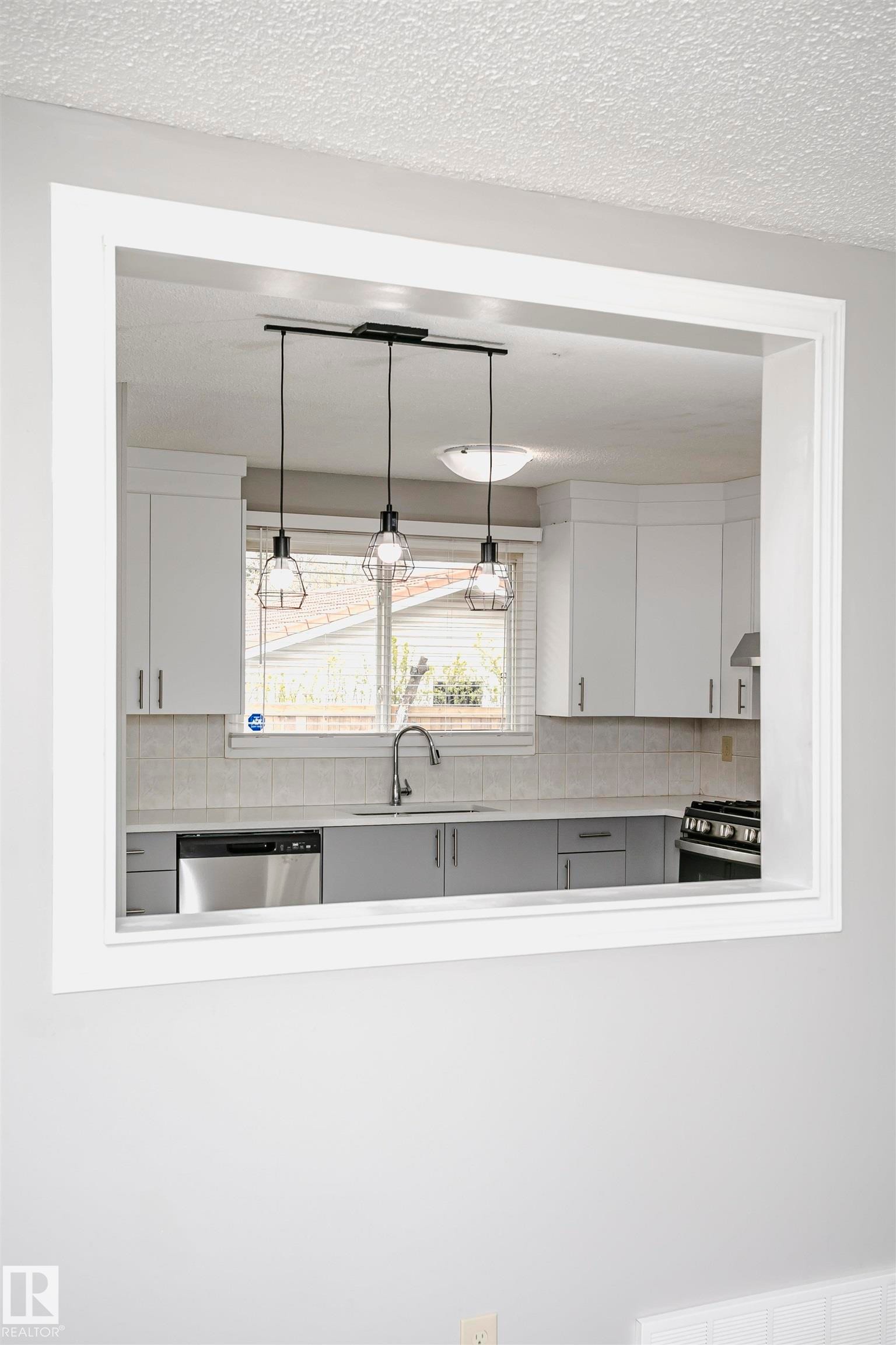 Convenient cut through window from living room into kitchen and dinette area adds natural light. - 11436 161 Avenue, Edmonton, AB - Indoor Photo Showing Kitchen