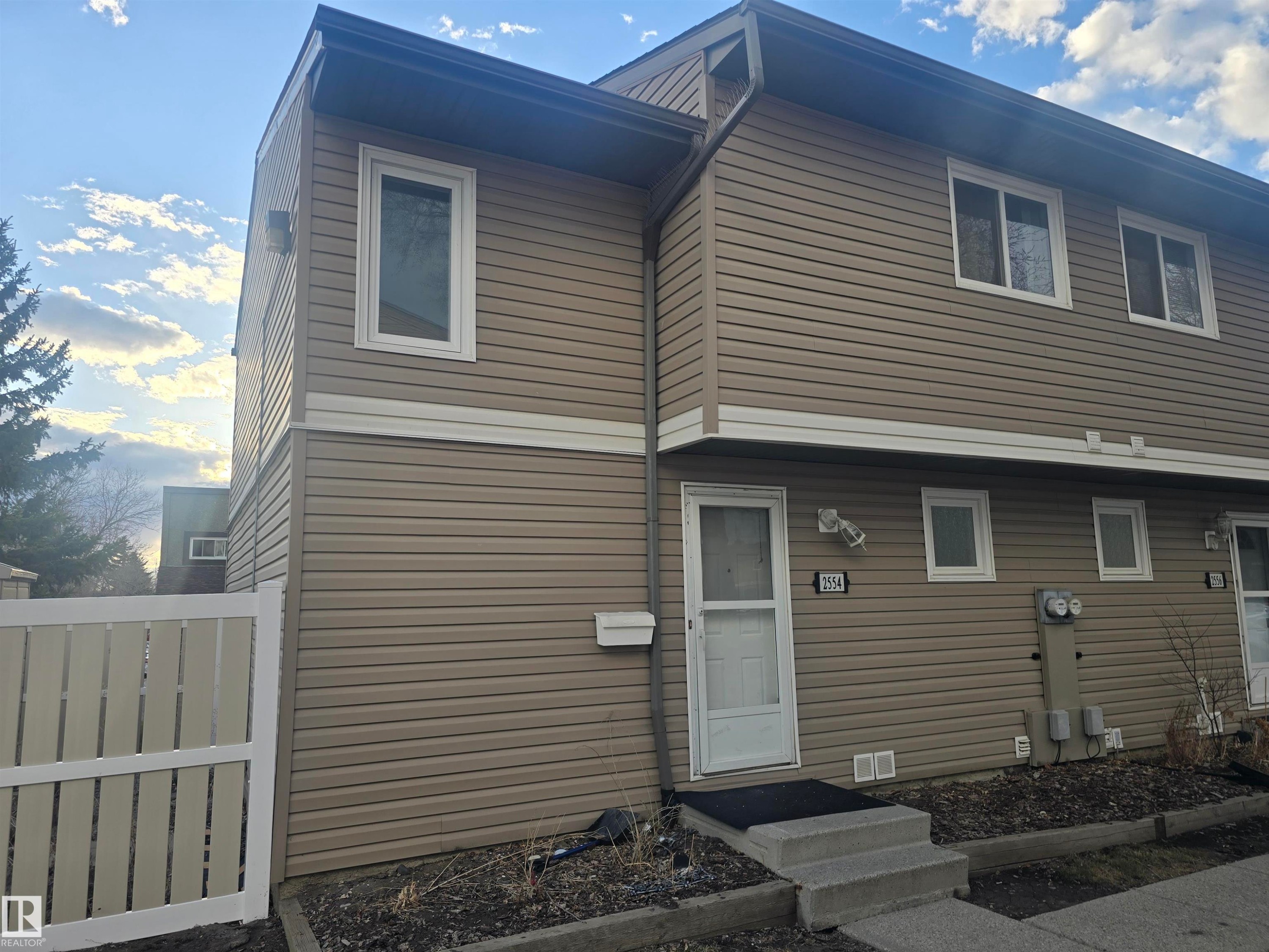 Exterior facade featuring tan horizontal siding with white trim - 2554 79 Street, Edmonton, AB - Outdoor