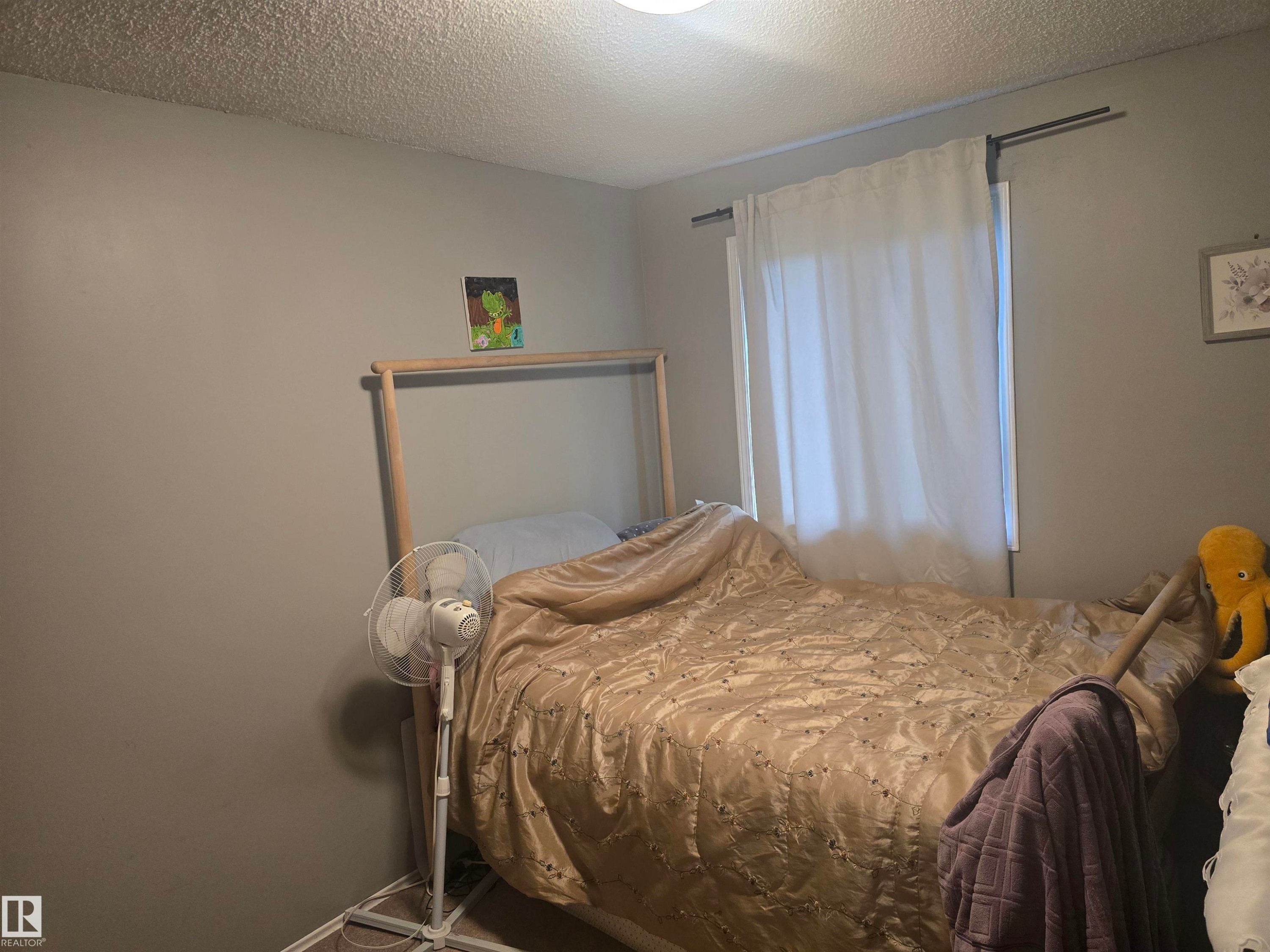Room with light grey walls, a white ceiling with a textured finish, and a centered flush-mount light fixture - 2554 79 Street, Edmonton, AB
