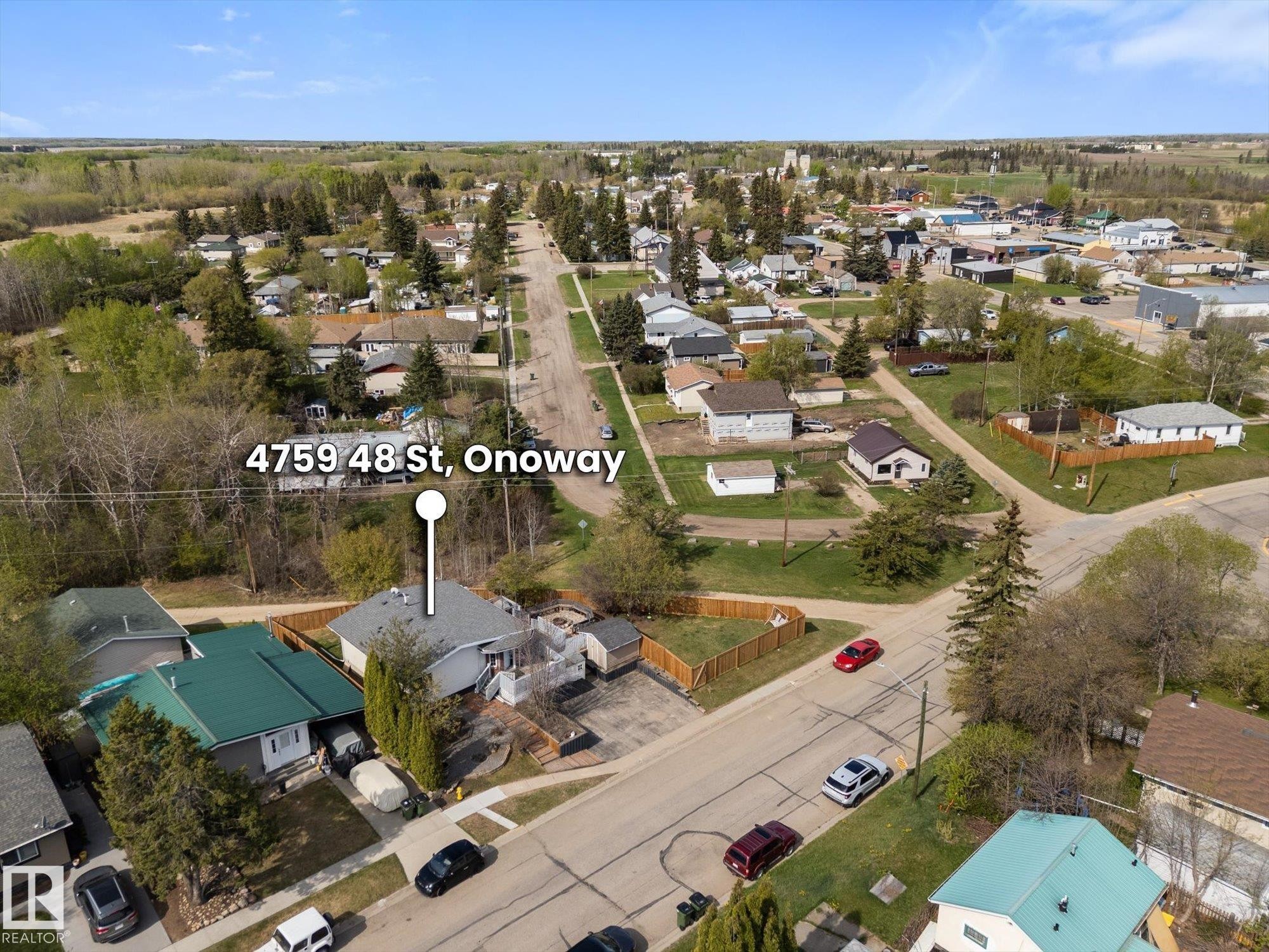Residential property featuring a grey shingled roof, a light-colored exterior, and an elevated deck with white railings - 4759 48 Street, Onoway, AB - Outdoor With View
