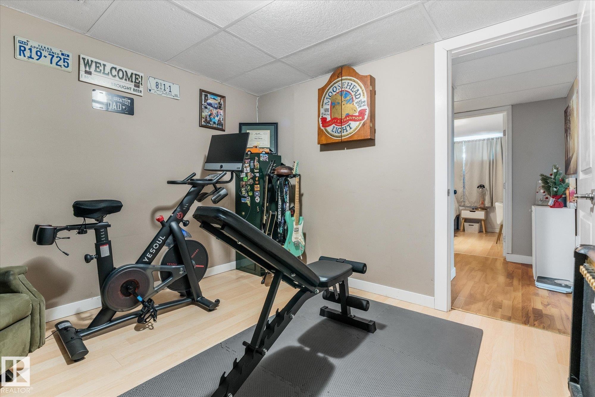 Versatile room featuring light wood-finish flooring, neutral wall paint, and a white acoustical tile ceiling - 4759 48 Street, Onoway, AB - Indoor Photo Showing Gym Room