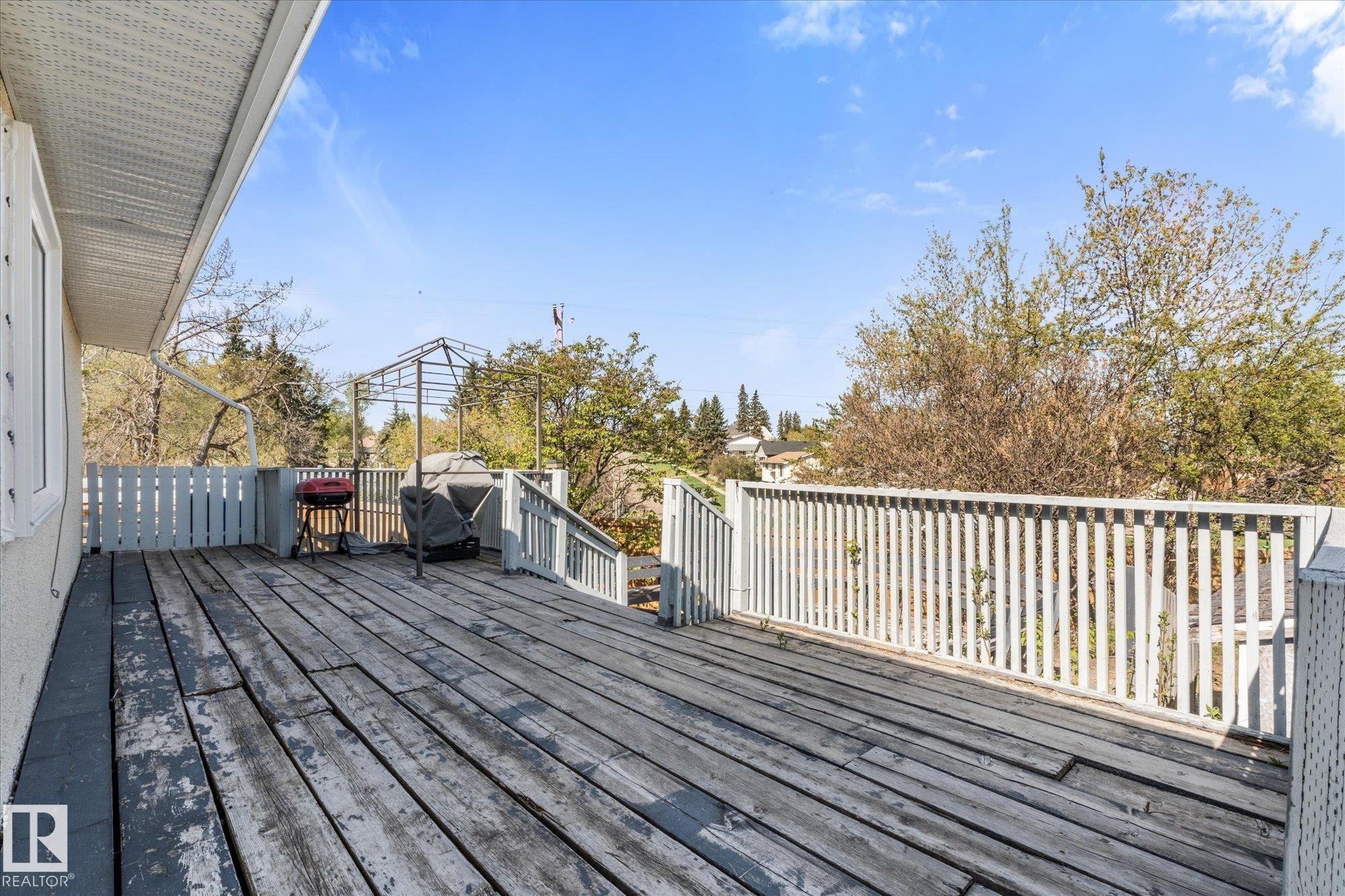 Spacious outdoor deck with wood flooring and white picket railings - 4759 48 Street, Onoway, AB - Outdoor With Deck Patio Veranda With Exterior