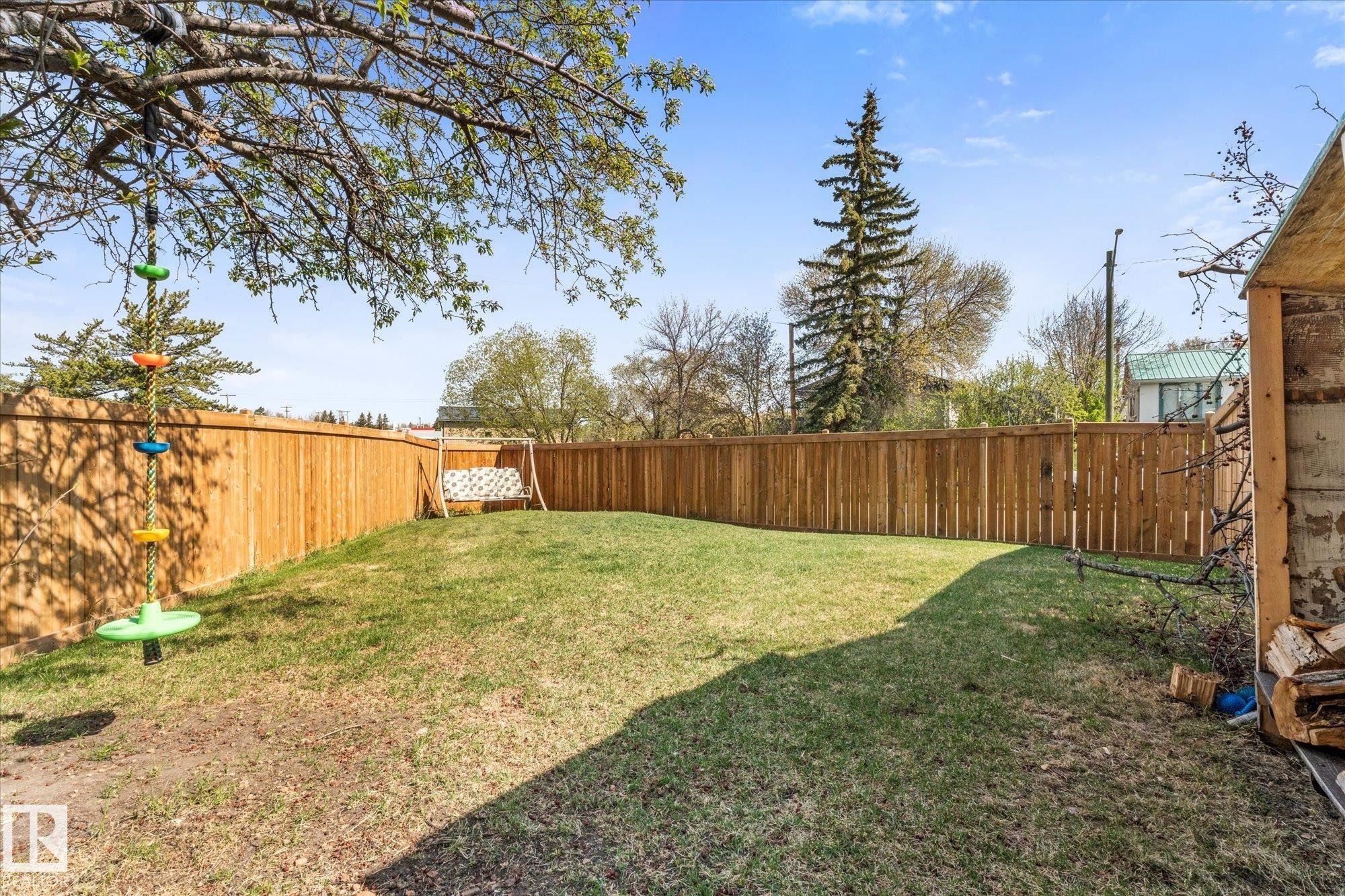 Expansive backyard featuring a new perimeter fence, mature trees, and a grassy lawn - 4759 48 Street, Onoway, AB - Outdoor With Backyard