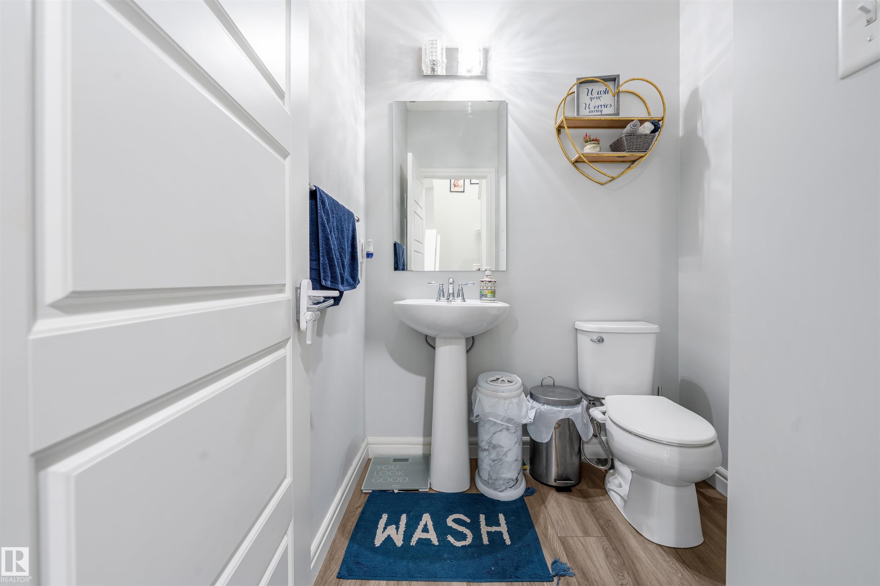 Pedestal sink with chrome faucet, mirror, and wall-mounted light fixture - 1024 Daniels Loop, Edmonton, AB - Indoor Photo Showing Bathroom