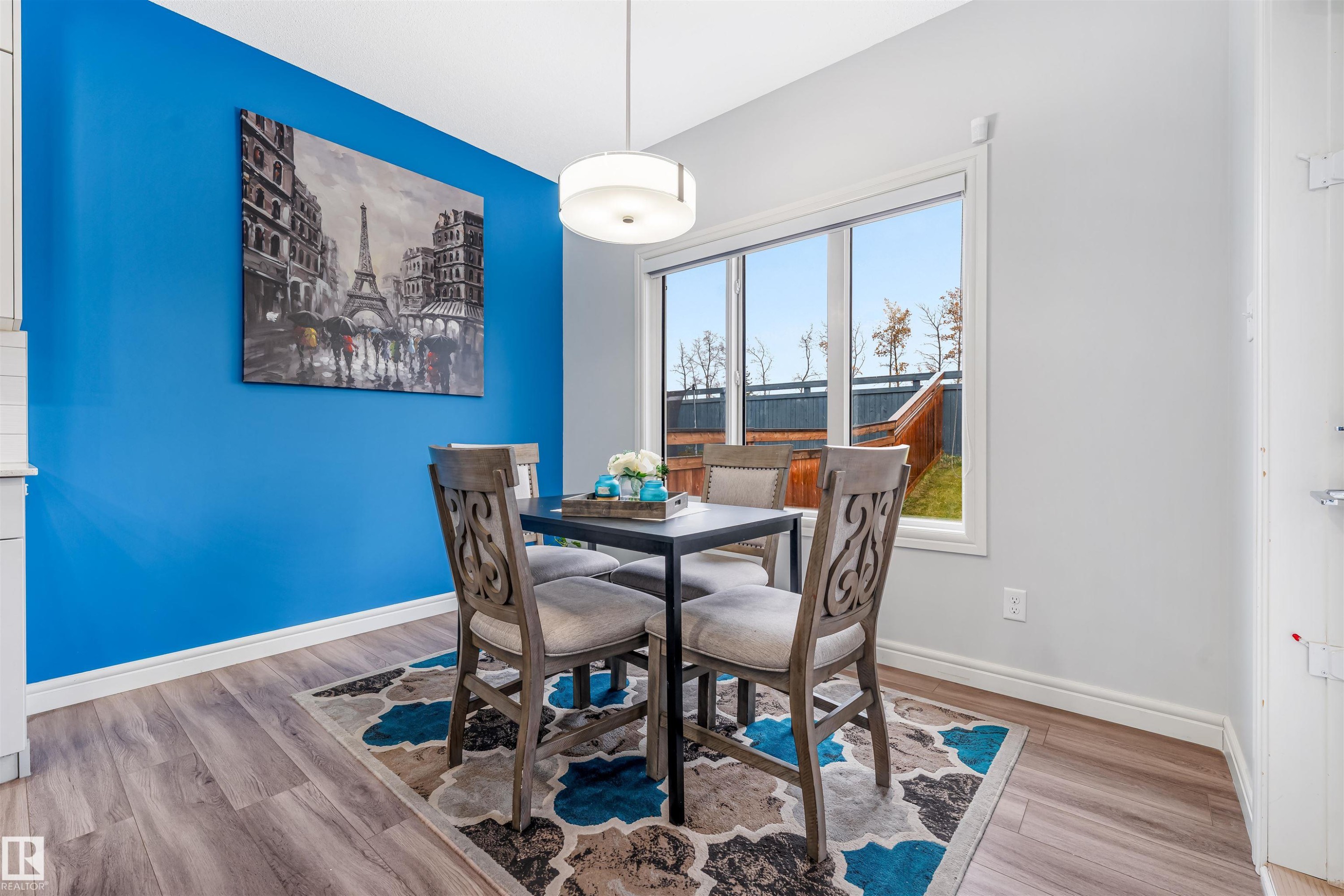 Dining area featuring wood-finish flooring and a bright accent wall - 1024 Daniels Loop, Edmonton, AB - Indoor Photo Showing Dining Room
