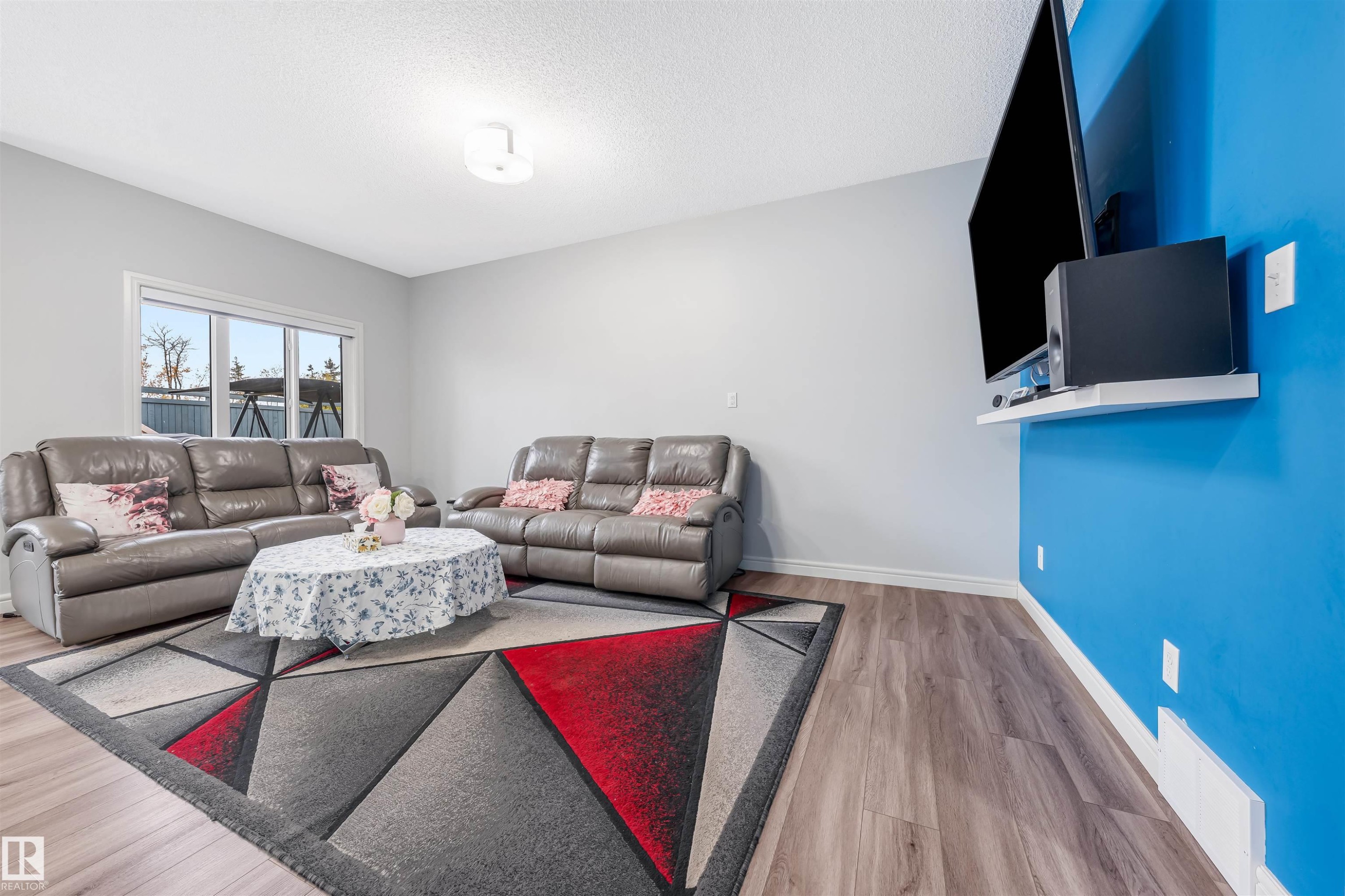 Bright living area featuring wood-finish flooring and a large window - 1024 Daniels Loop, Edmonton, AB - Indoor Photo Showing Living Room